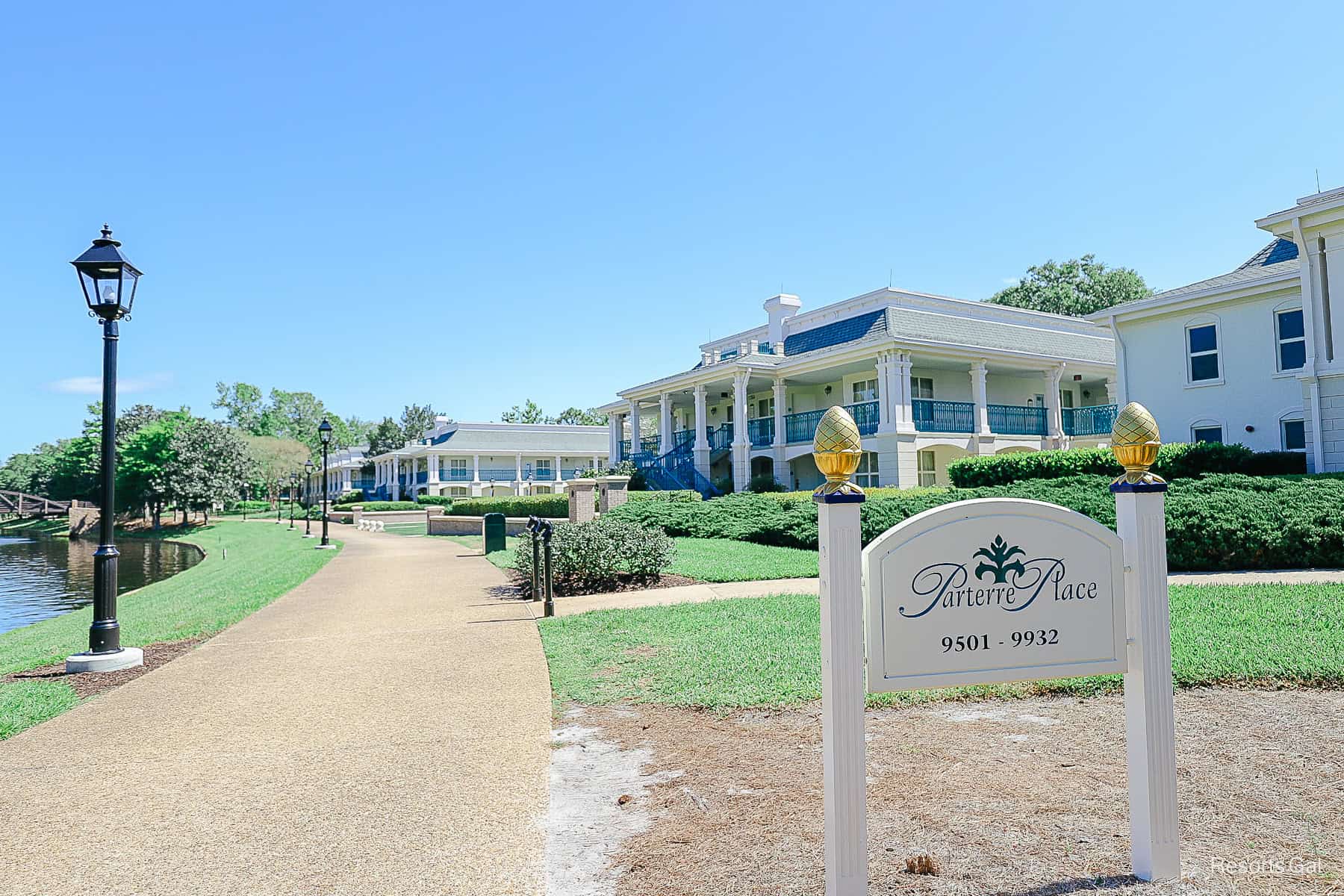 a sign that says Parterre Place with the walking path in front of the Royal Rooms at Port Orleans Riverside 