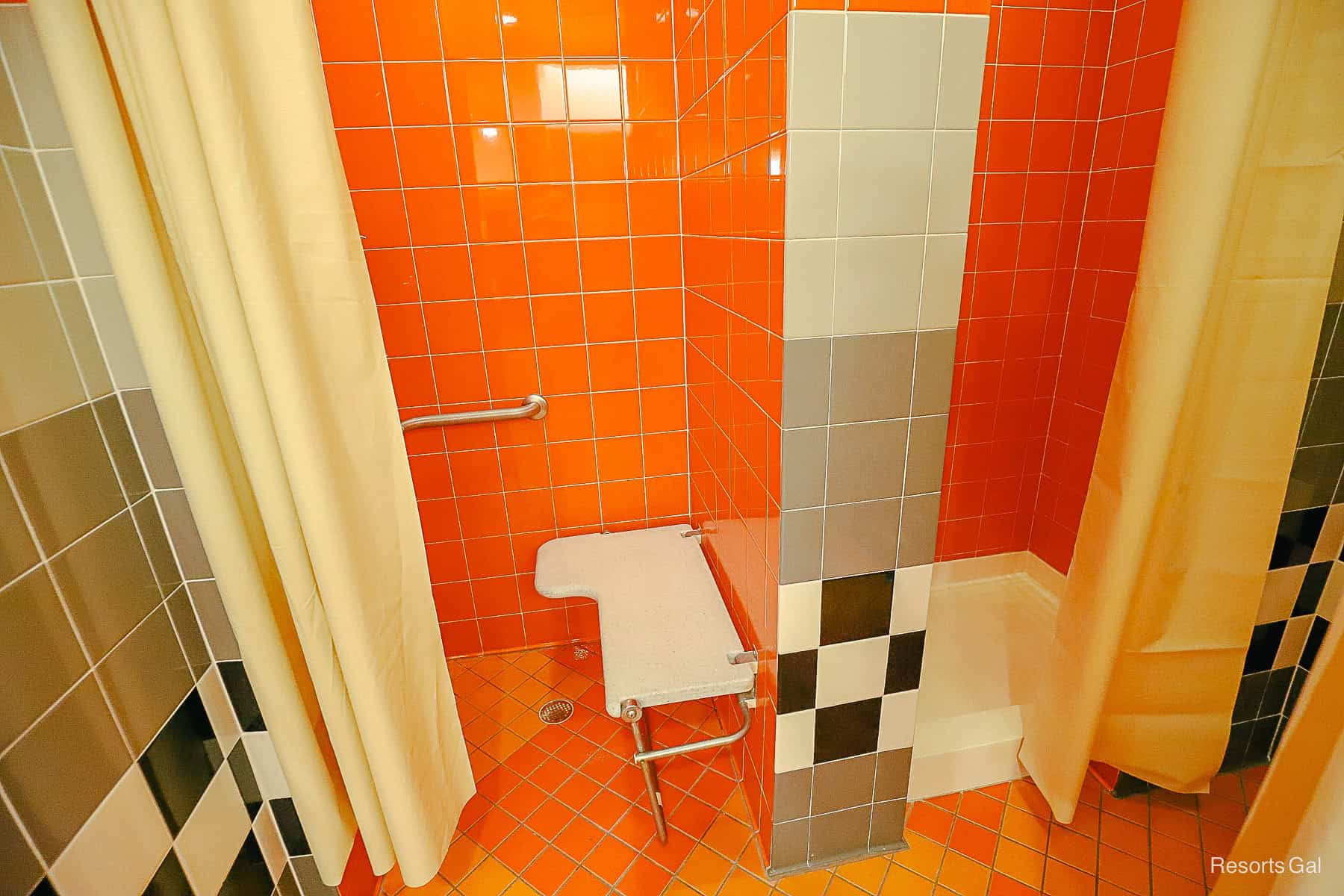 a regular shower stall and a handicapped shower stall at Art of Animation Resort Pool 