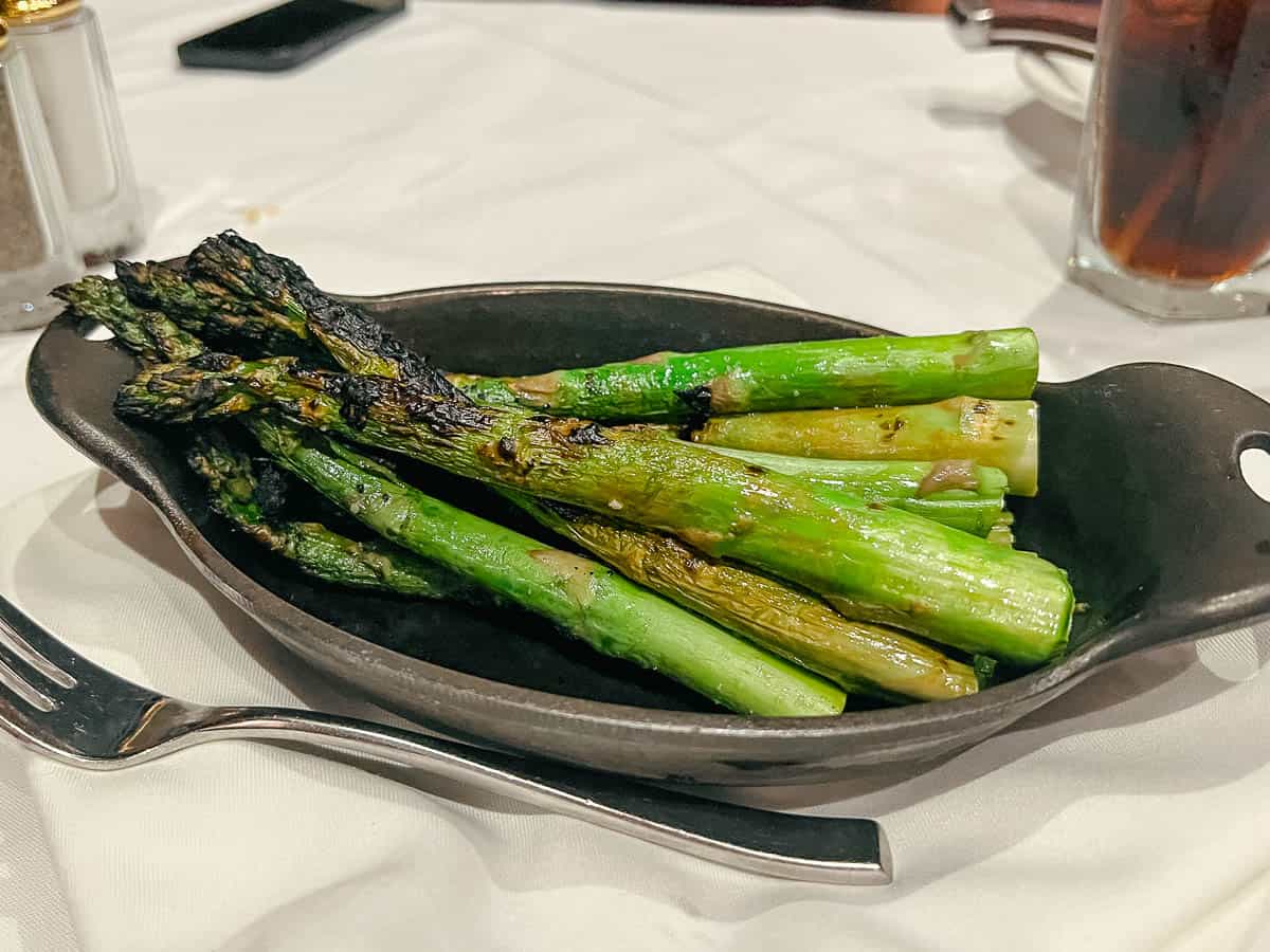 a cast iron skillet with charred asparagus from a signature dining restaurant 