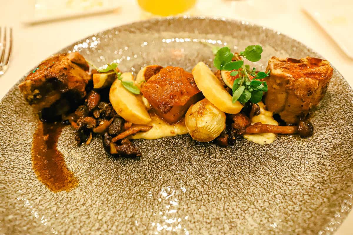 an entree with pork, polenta, and figs from a fine dining restaurant 