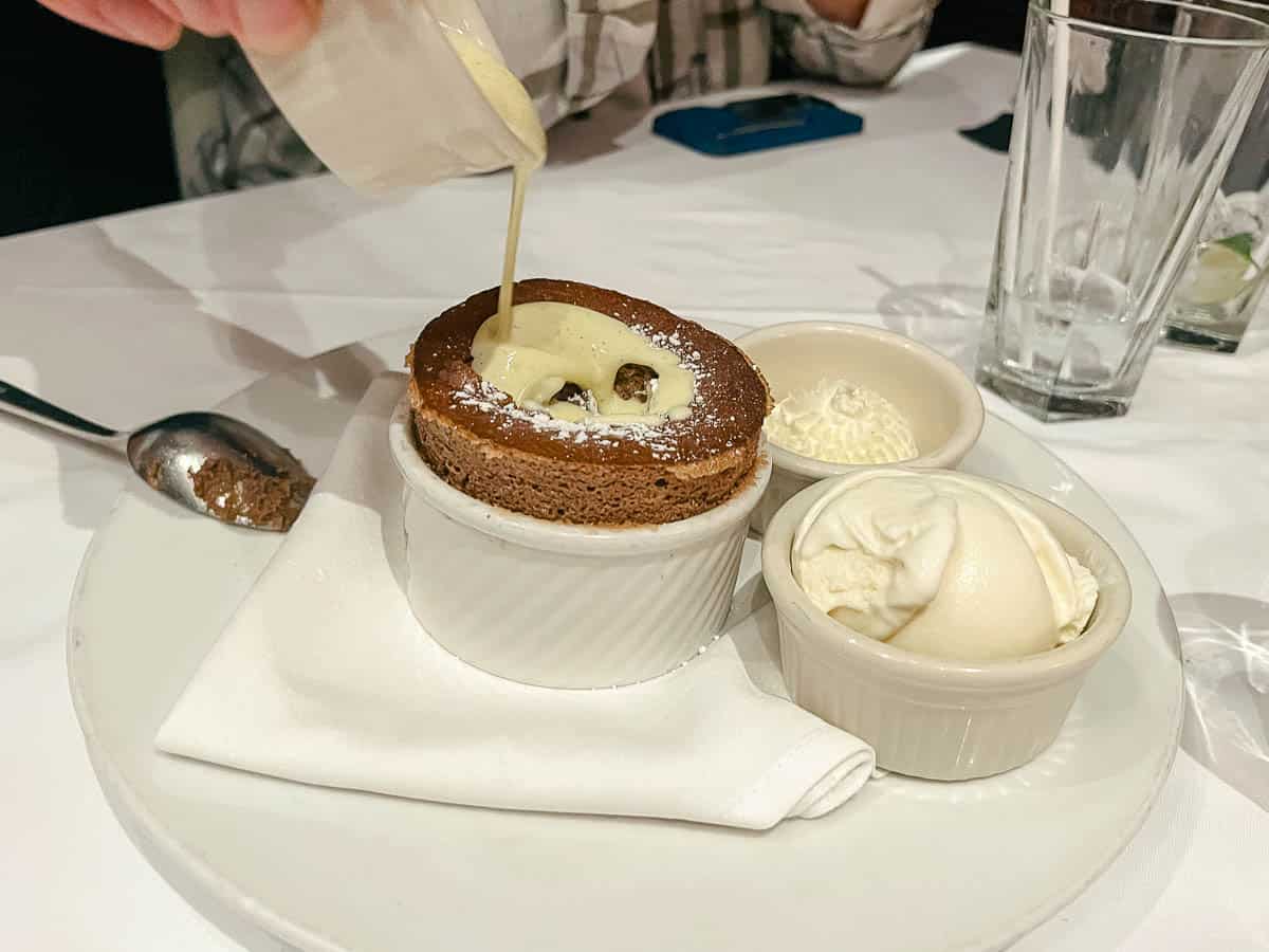 a server drizzling sauce over a chocolate souffle at one of Disney's signature restaurants 