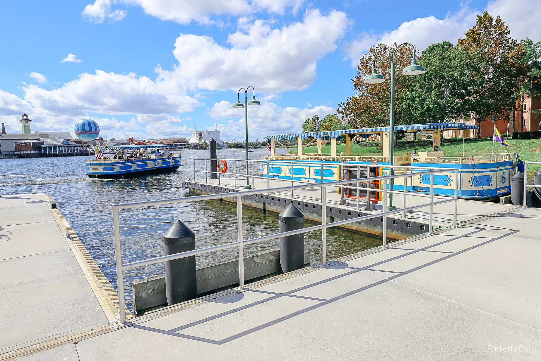 a boat pulling up to dock at Disney Springs and a boat with a purple and yellow flag 