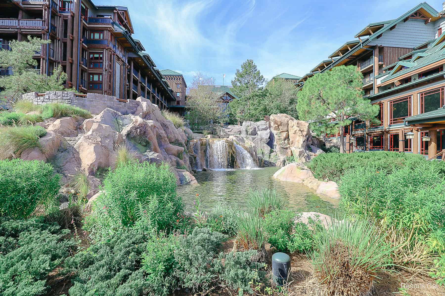 a relaxing scene of waterfalls with Disney's Wilderness Lodge in the backdrop 