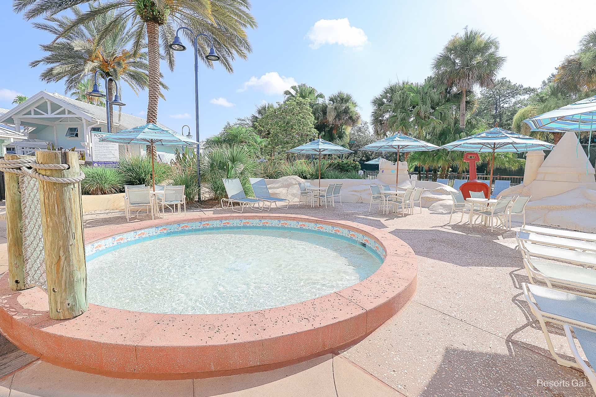 the resort's kiddie pool with loungers, tables, and chairs around it 