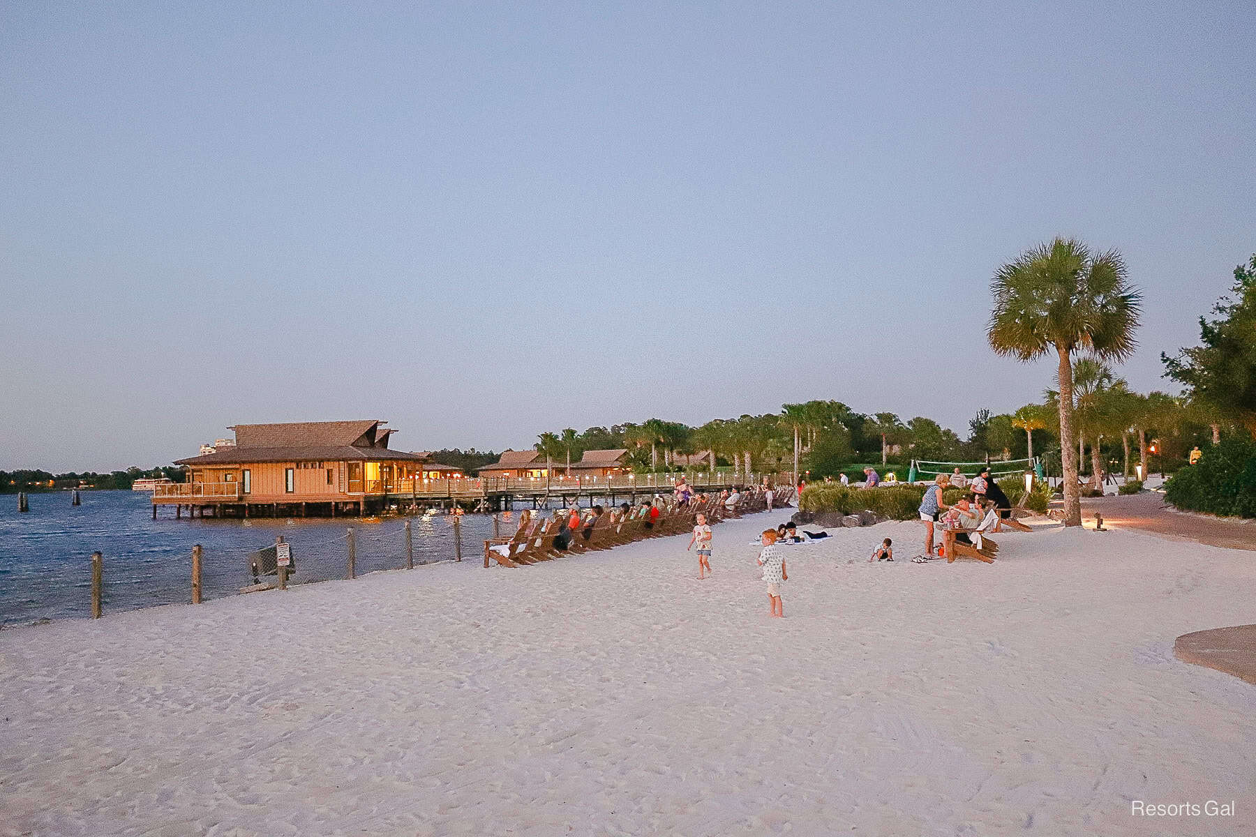 Guests waiting to see the Electrical Water Pageant from Disney's Polynesian Village Resort beach 