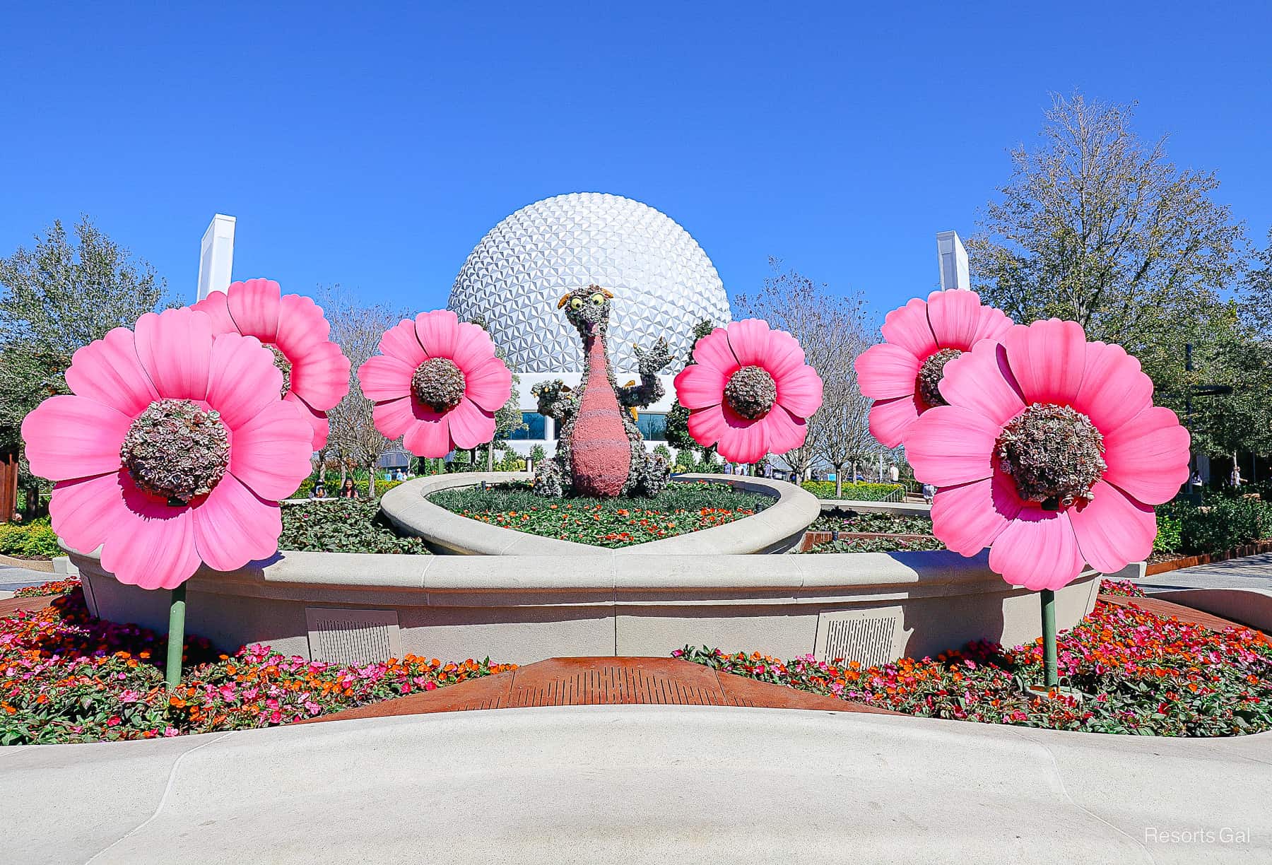 Figment topiary surrounded by pink flowers