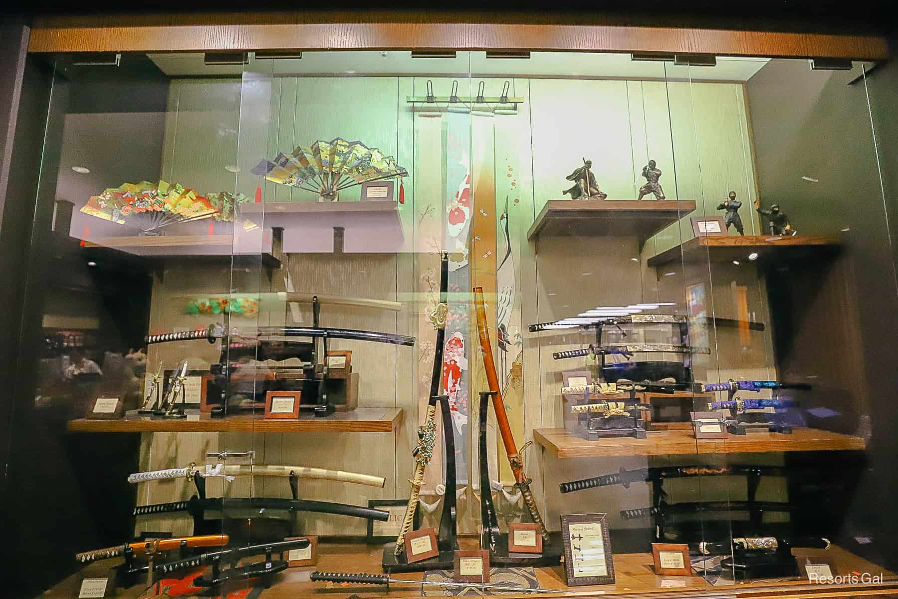 a locked display case with various Japanese items 