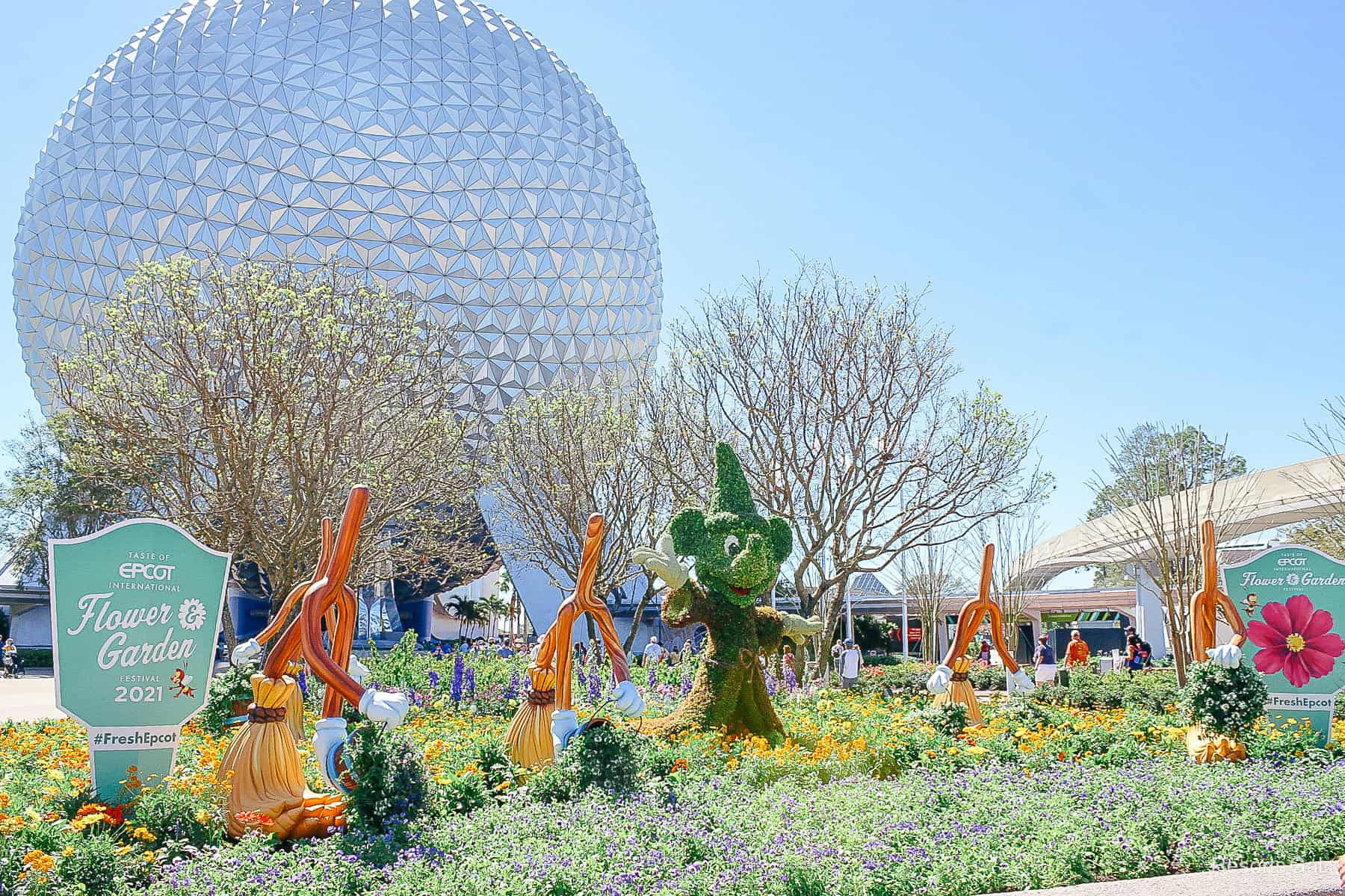 Sorcerer Mickey topiary appears to wave to guests at Epcot's entrance 