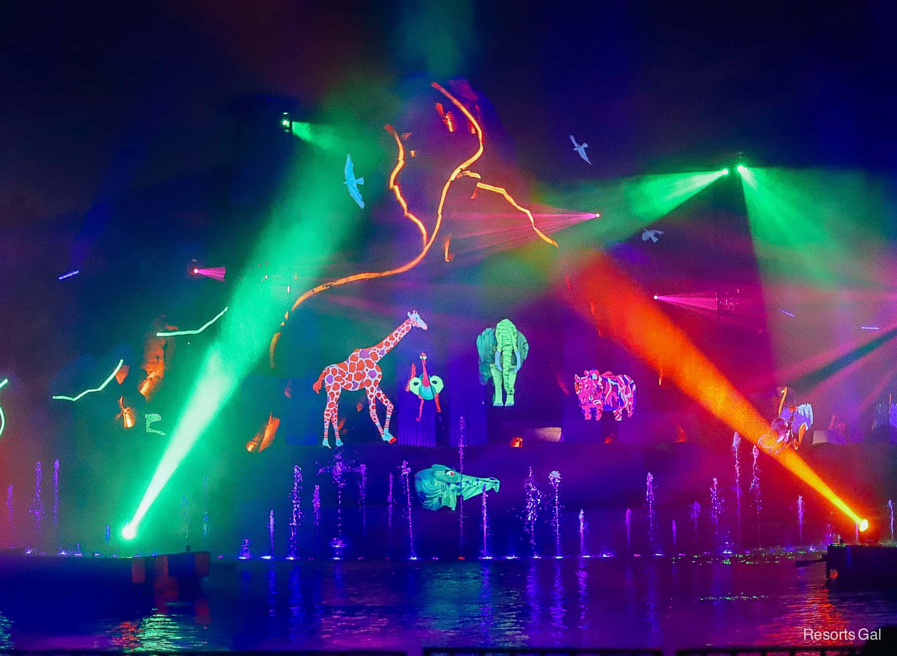 a brightly lit neon scene with animals during Fantasmic! 