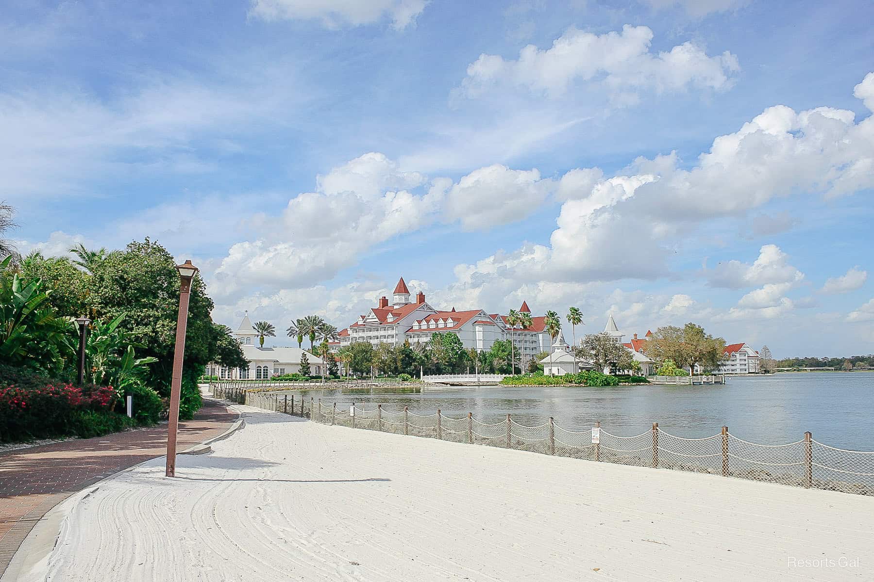 the walkway has a sandy beach area beside it 