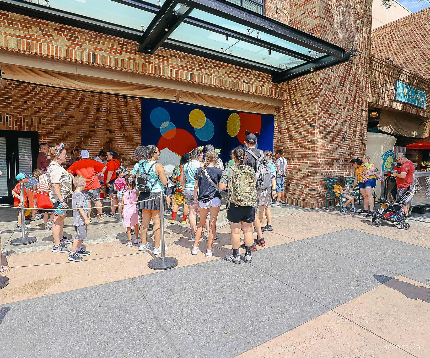 guests waiting in a long queue to meet Joy at Pixar Plaza 