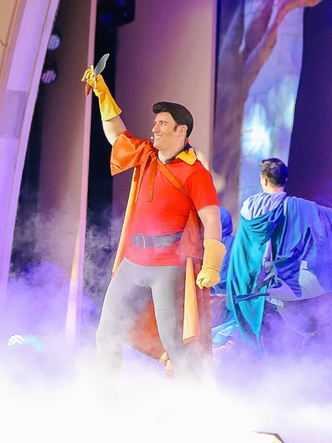 Gaston holds up a knife on stage during Beauty and the Beast Live. 