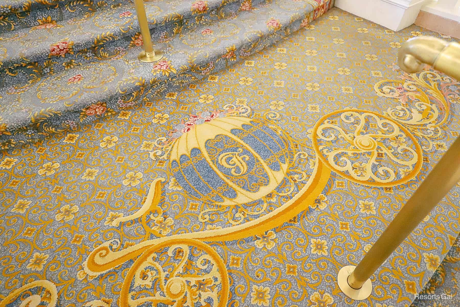 Cinderella carriage medallion with Grand Floridian logo on the lobby stairs 