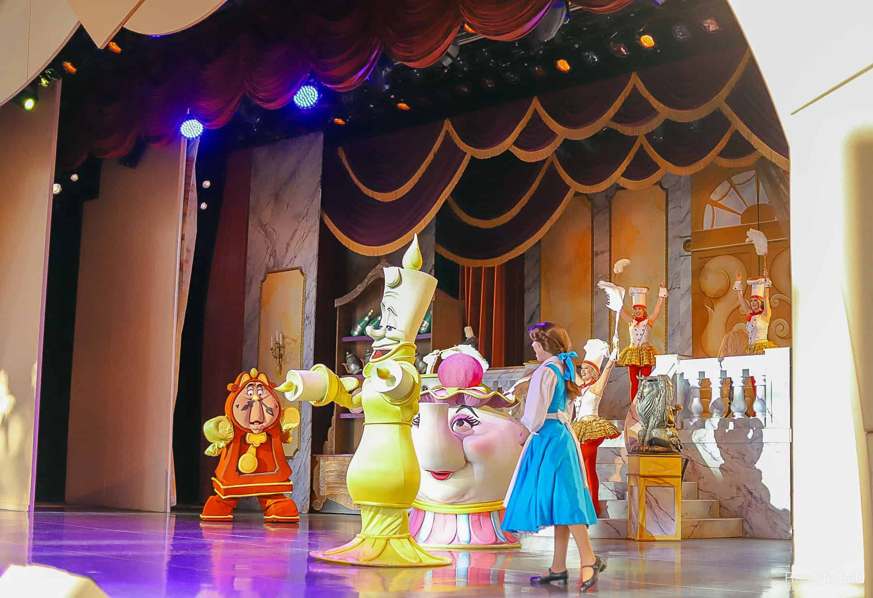 a scene with Belle and characters from Beauty and the Beast at BATB Live on Stage at Disney's Hollywood Studios. 