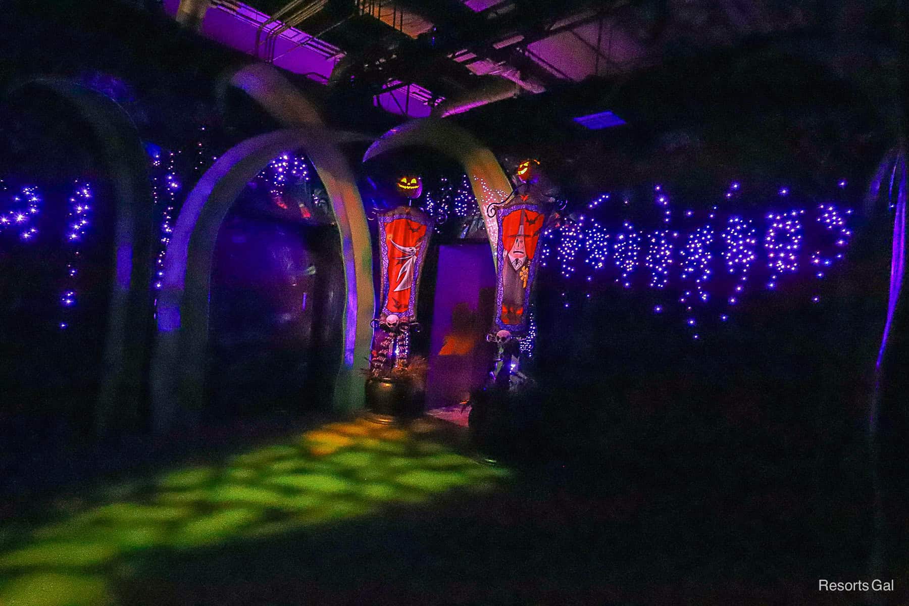 a dark waiting area with purple lights and Nightmare Before Christmas Decorations at Jack Skellington and Sally's meet-and-greet 