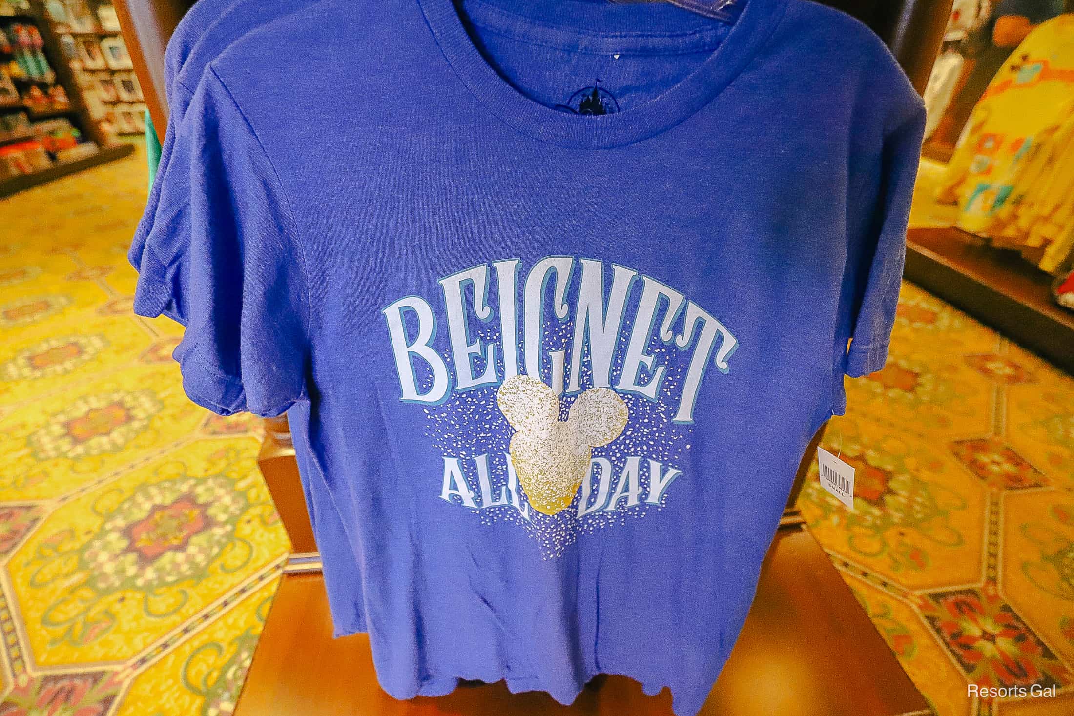 a blue shirt that says Beignet all day with a Mickey-shaped beignet printed on it 