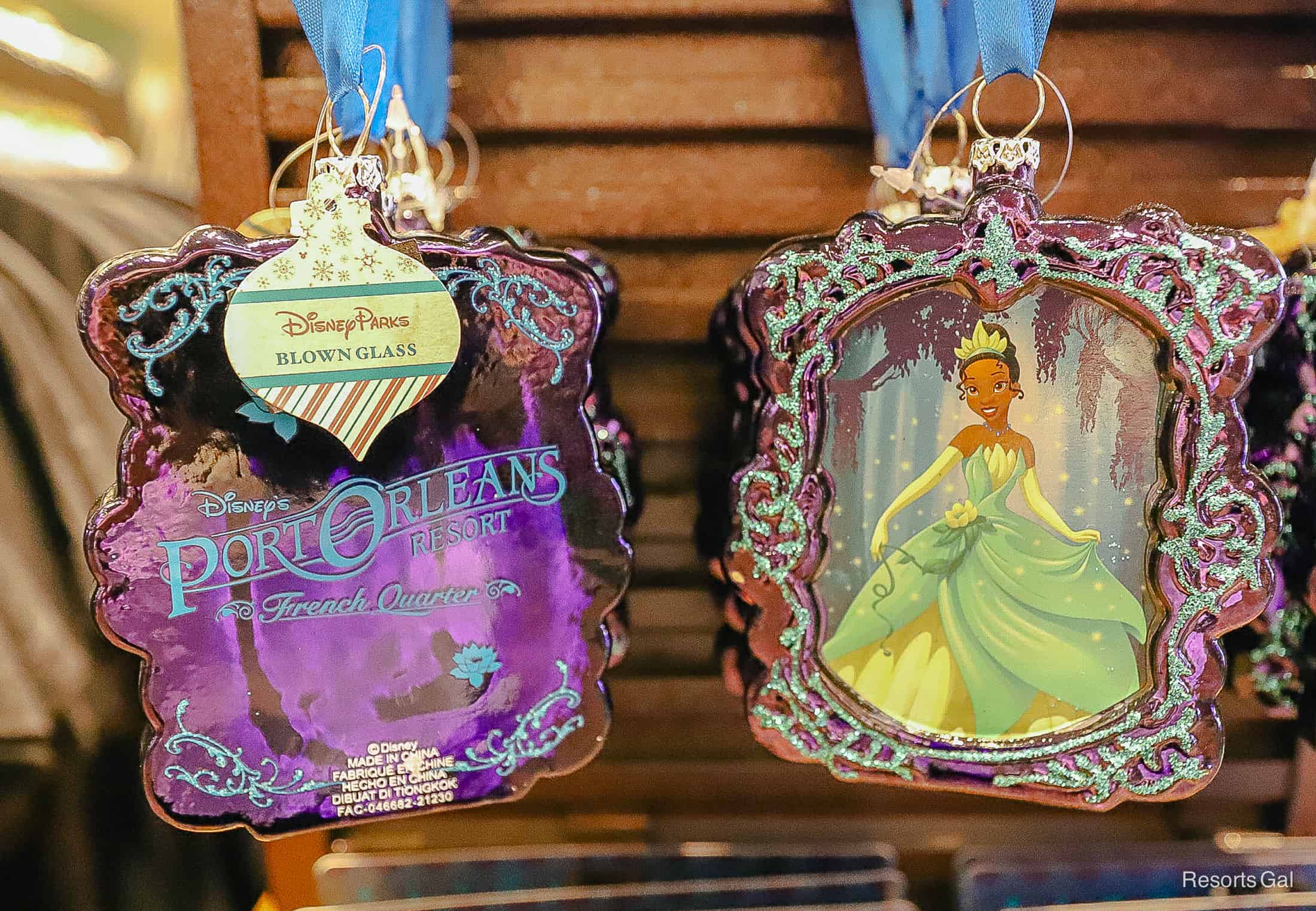 a resort ornament that's made of blown glass with Port Orleans French Quarter on one side and Tiana on the opposite 