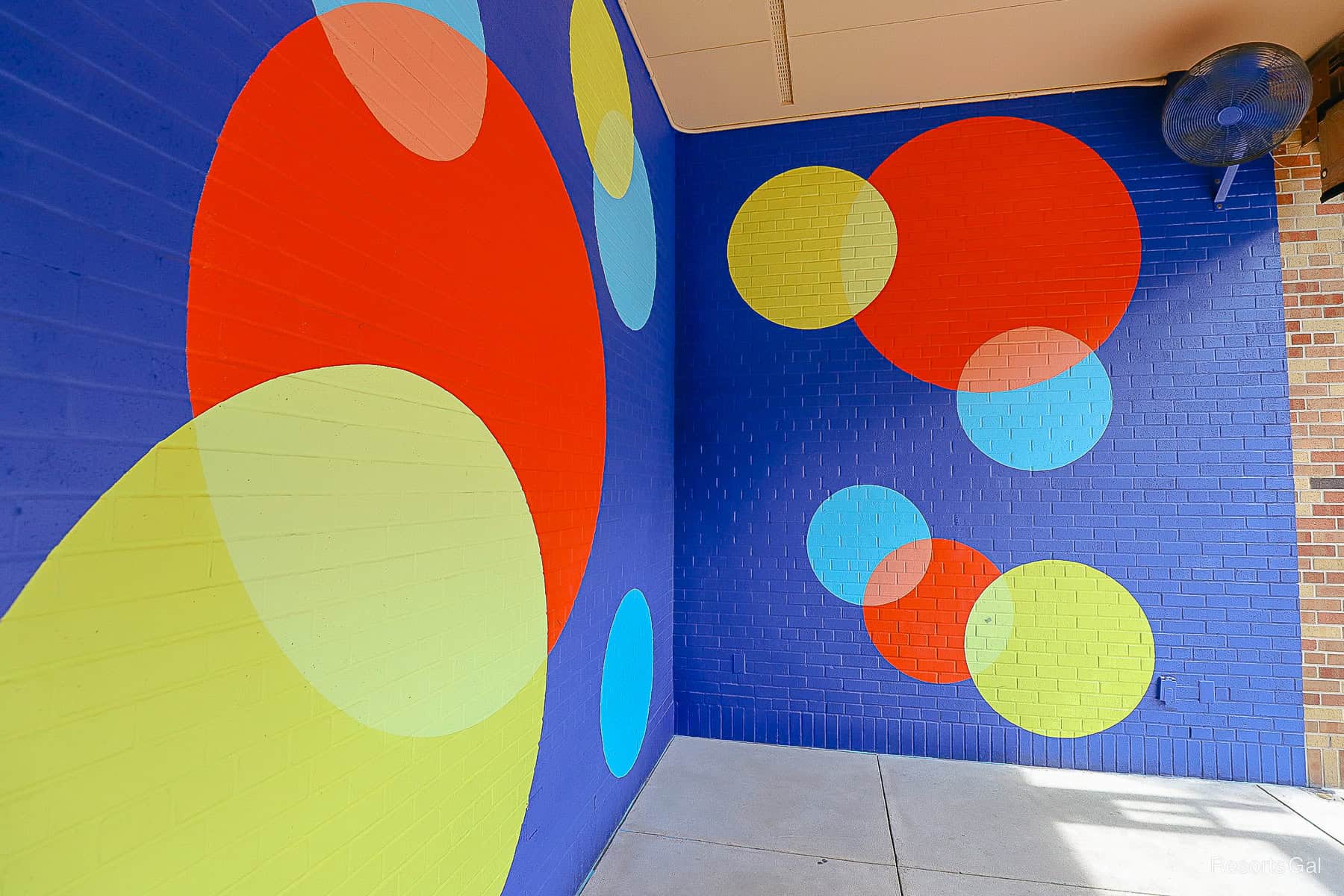 Joy's themed background with blue painted brick and yellow, red, and light blue circles 
