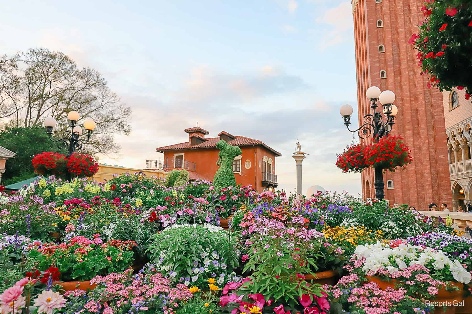 Lady and the Tramp facing the sunset. Colorful flowers surround them in pink, whites, yellows, purples and reds.