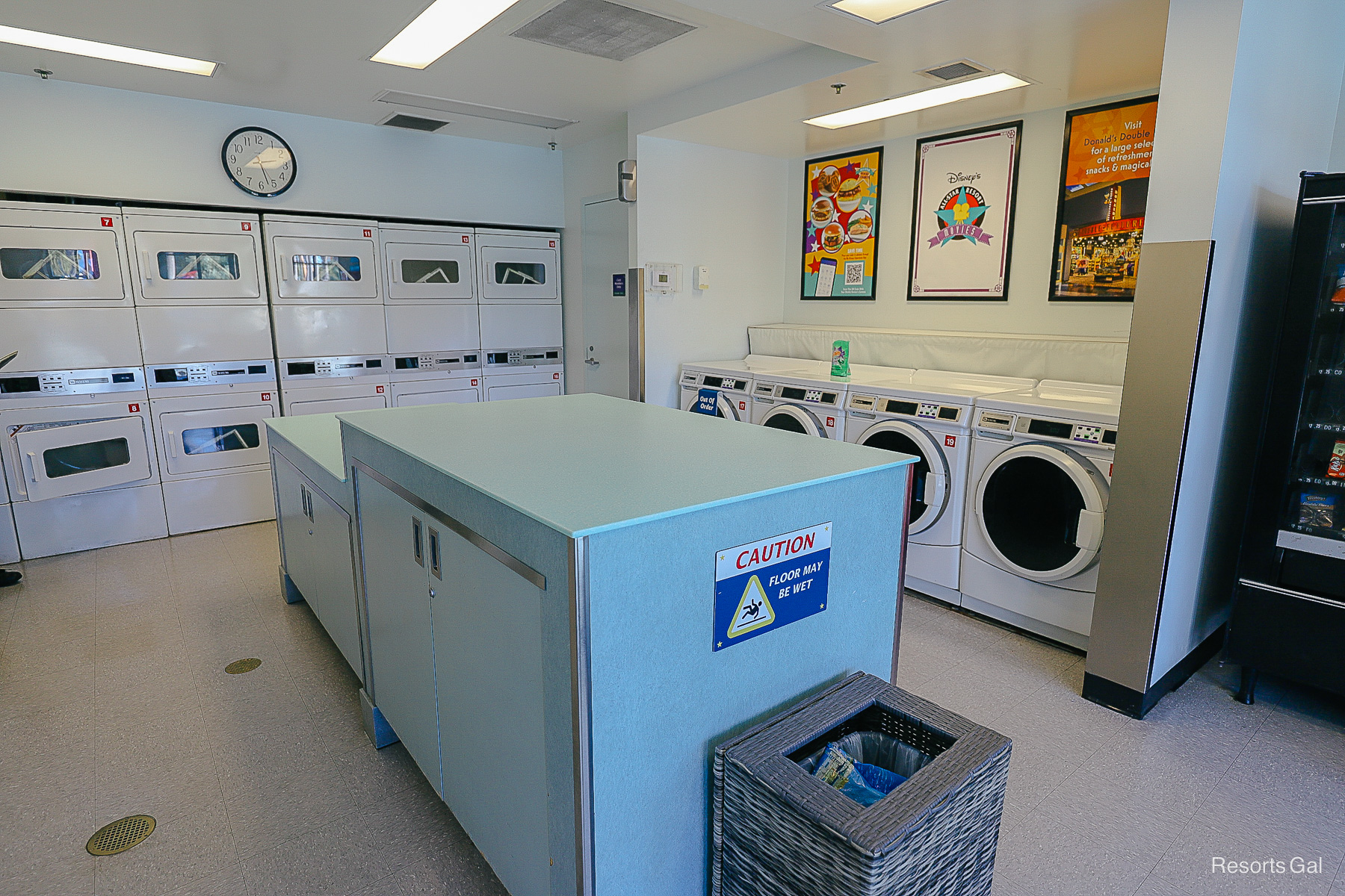 interior of the laundry room with washers, dryers, and a folding table 