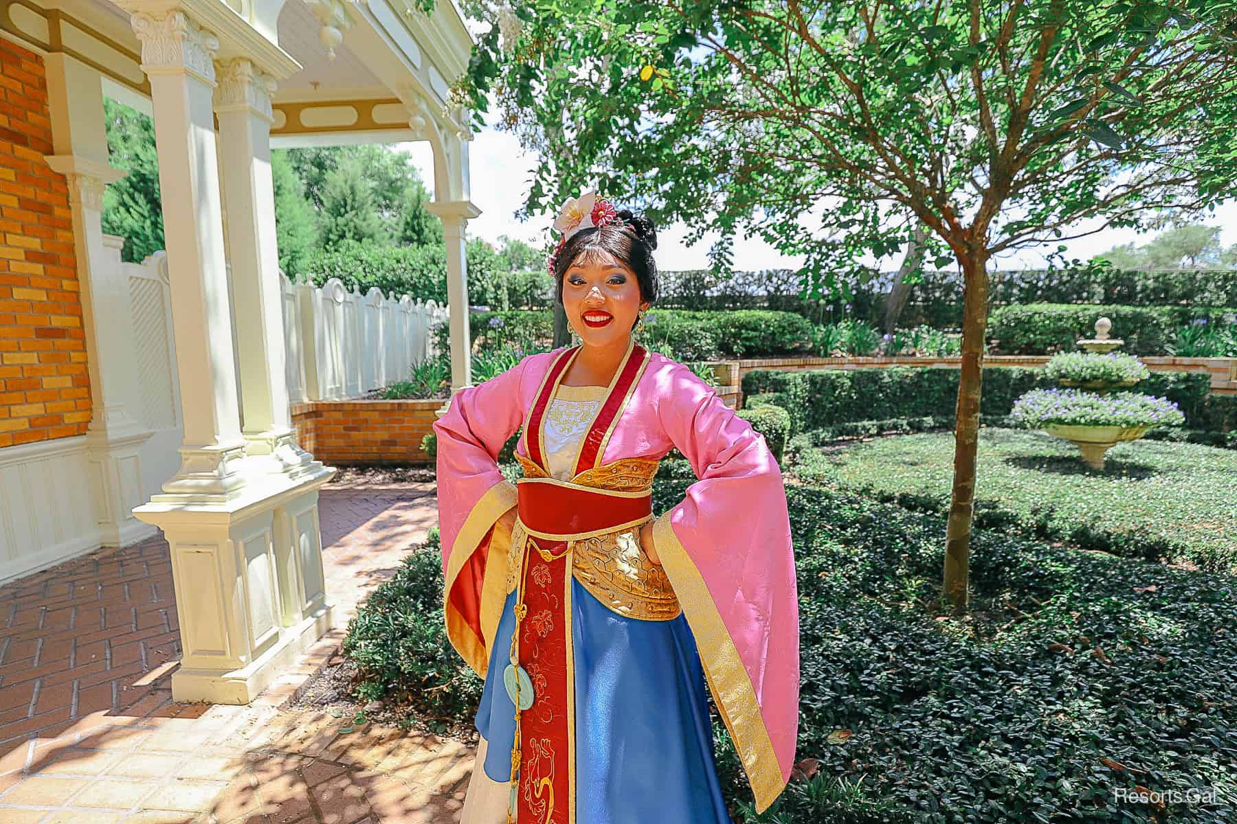 Mulan poses for a photo in her traditional gown at Magic Kingdom. 