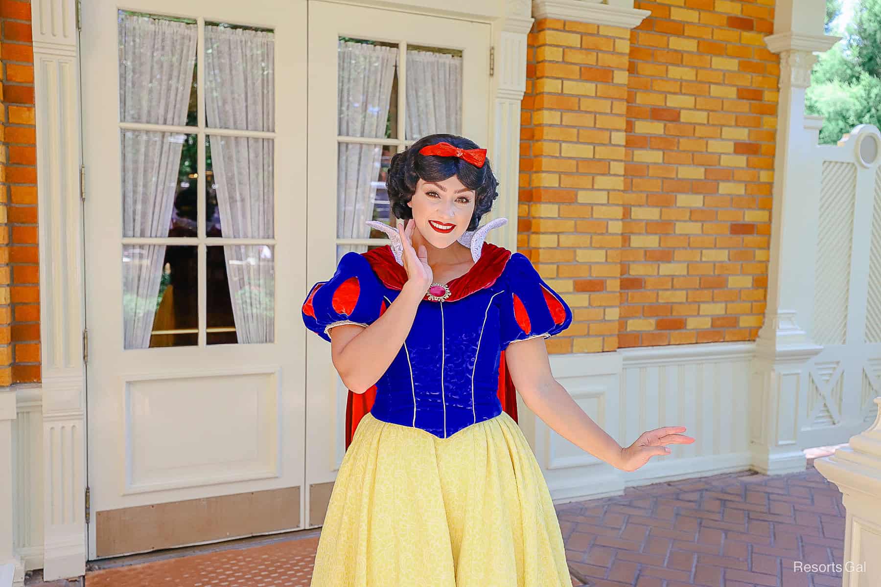 Snow White poses on the side patio of Town Square Theater at Magic Kingdom. 