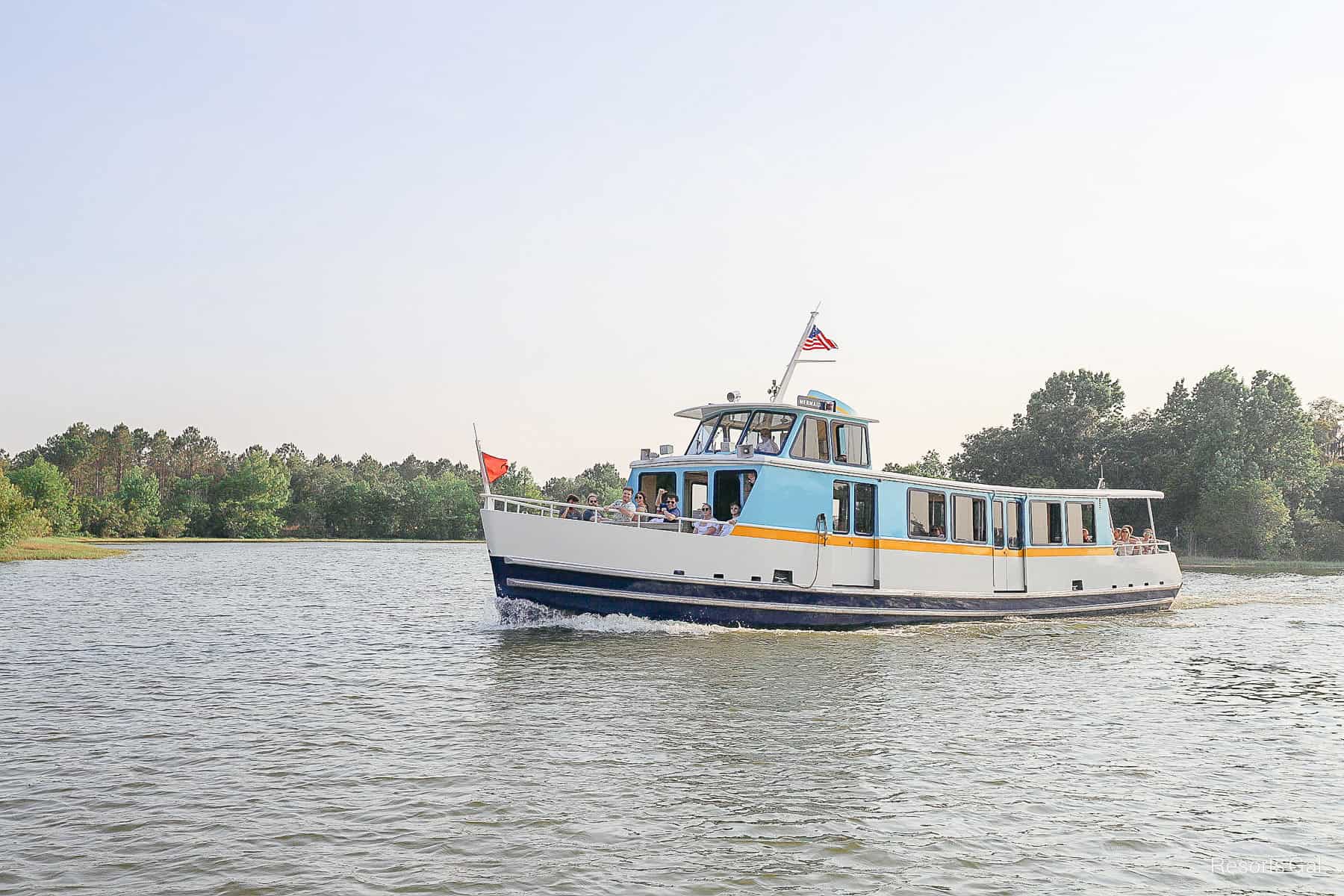 a large boat with a red flat on its way to Magic Kingdom 