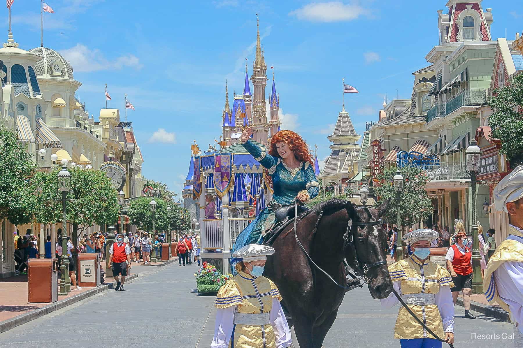 Merida riding a black horse in a cavalcade. 