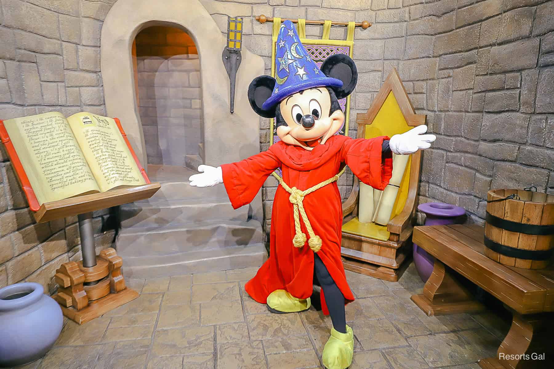 Mickey poses with arms spread in his red sorcerer's robe 