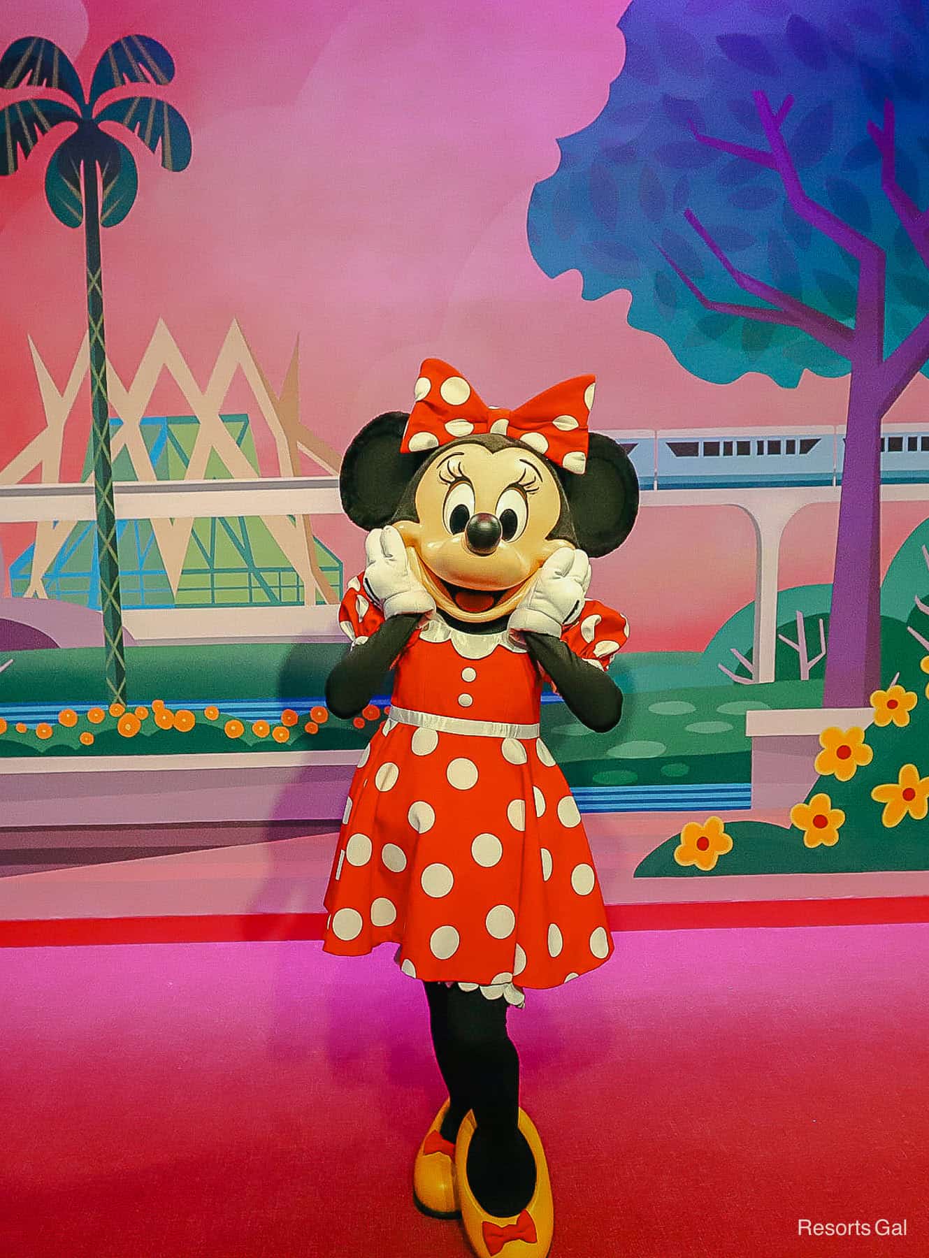 Minnie smiles with hands on her cheeks at the Mickey and Friends spot at Epcot.