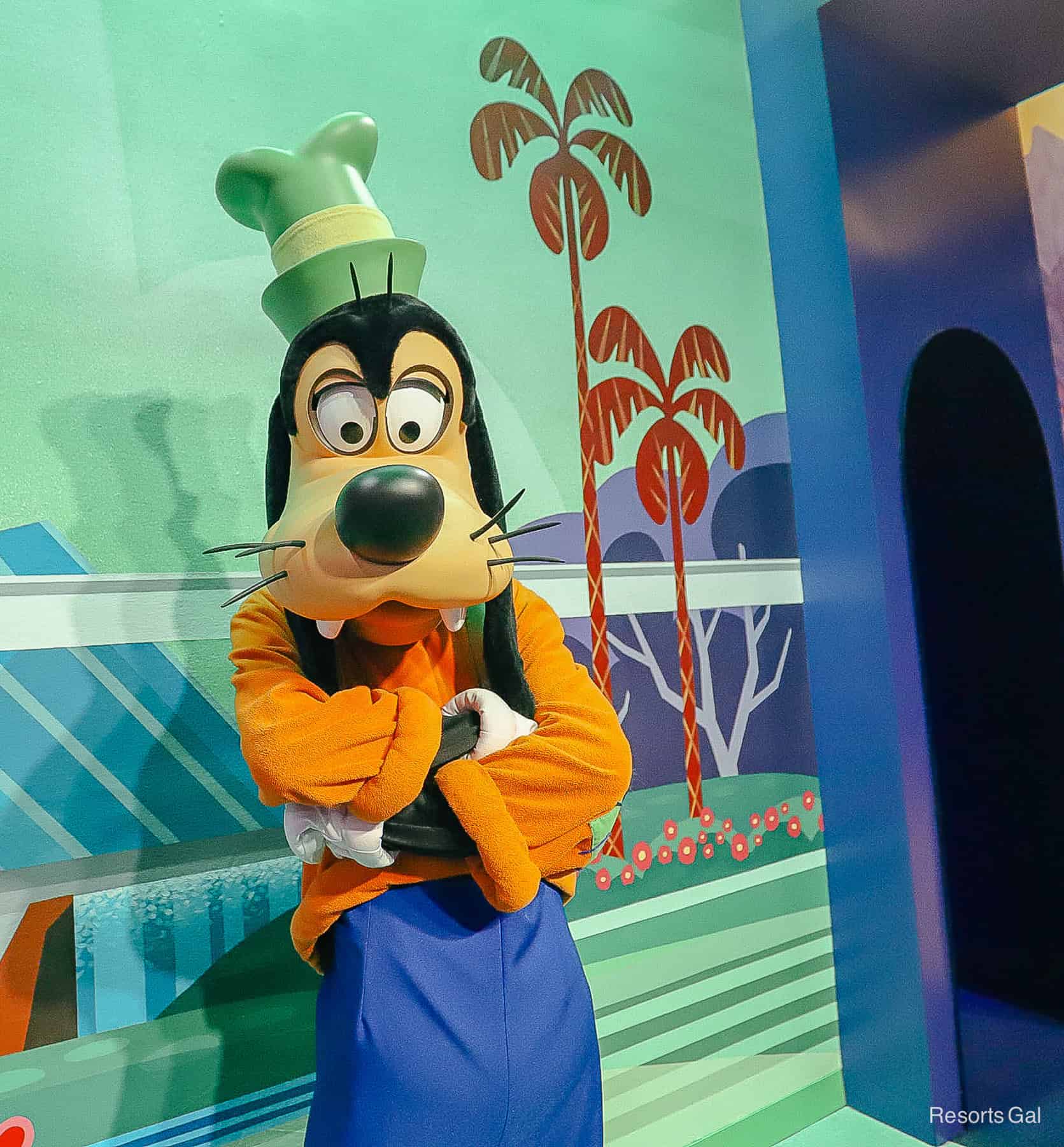 Goofy poses at the Mickey and Friends meet with his arms crossed. 