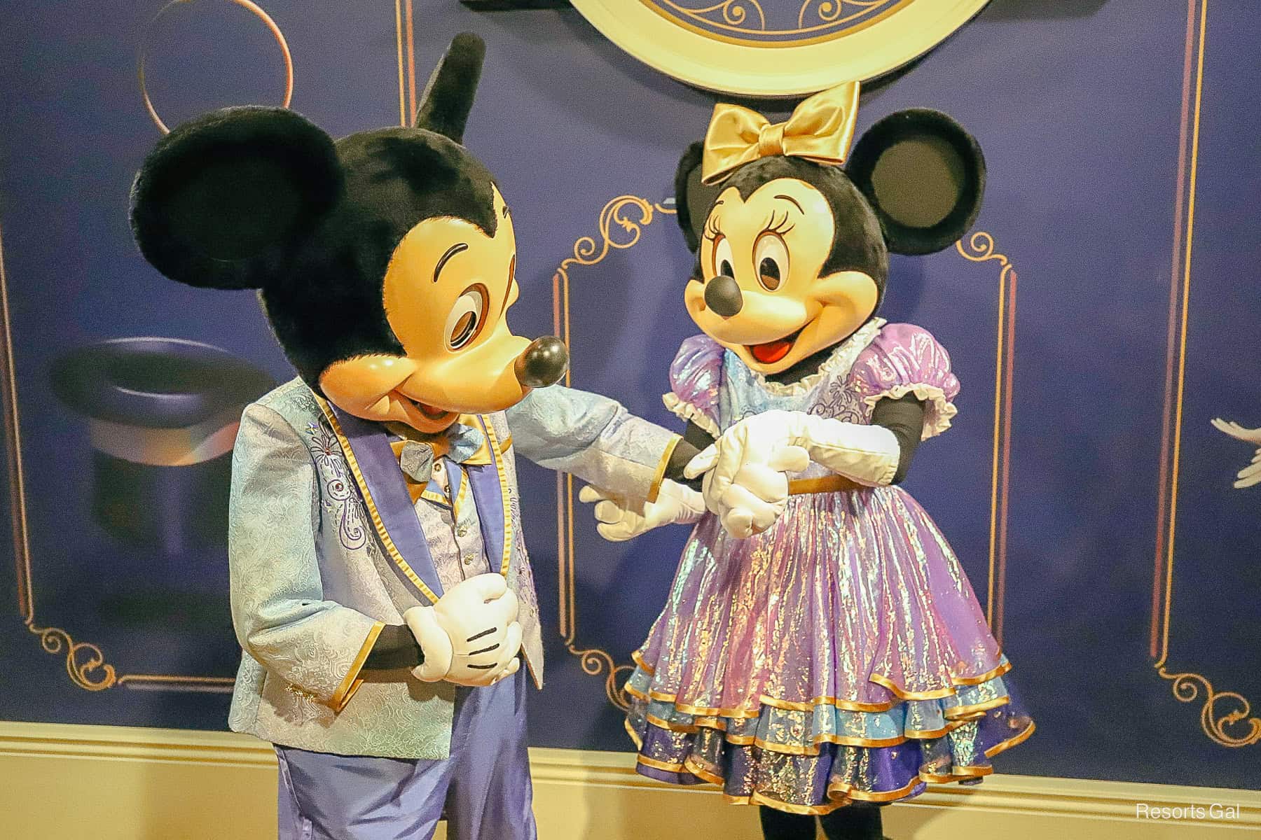 Mickey extends a hand to Minnie Mouse 