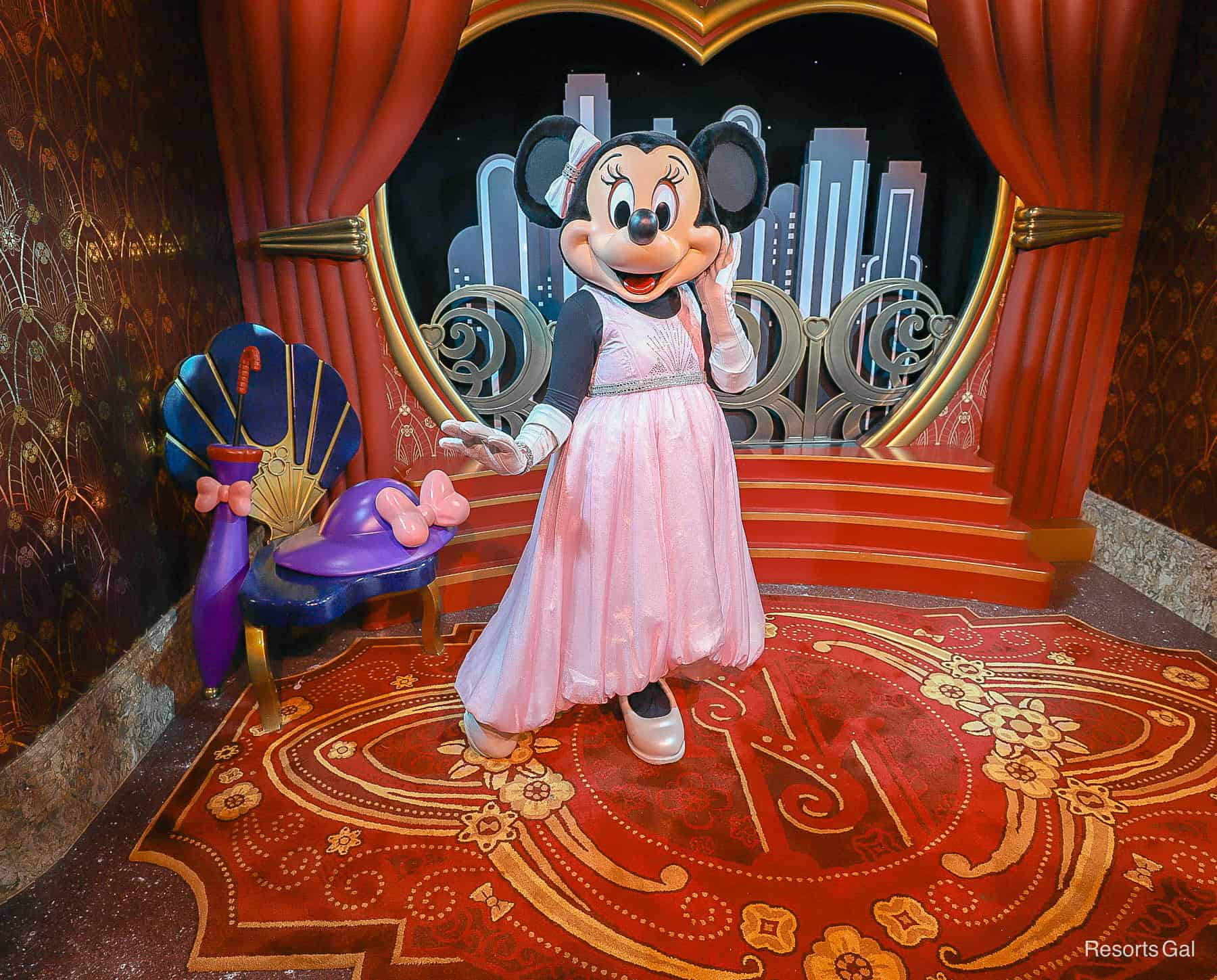 Minnie Mouse wears a pink ballgown and pink bow. 