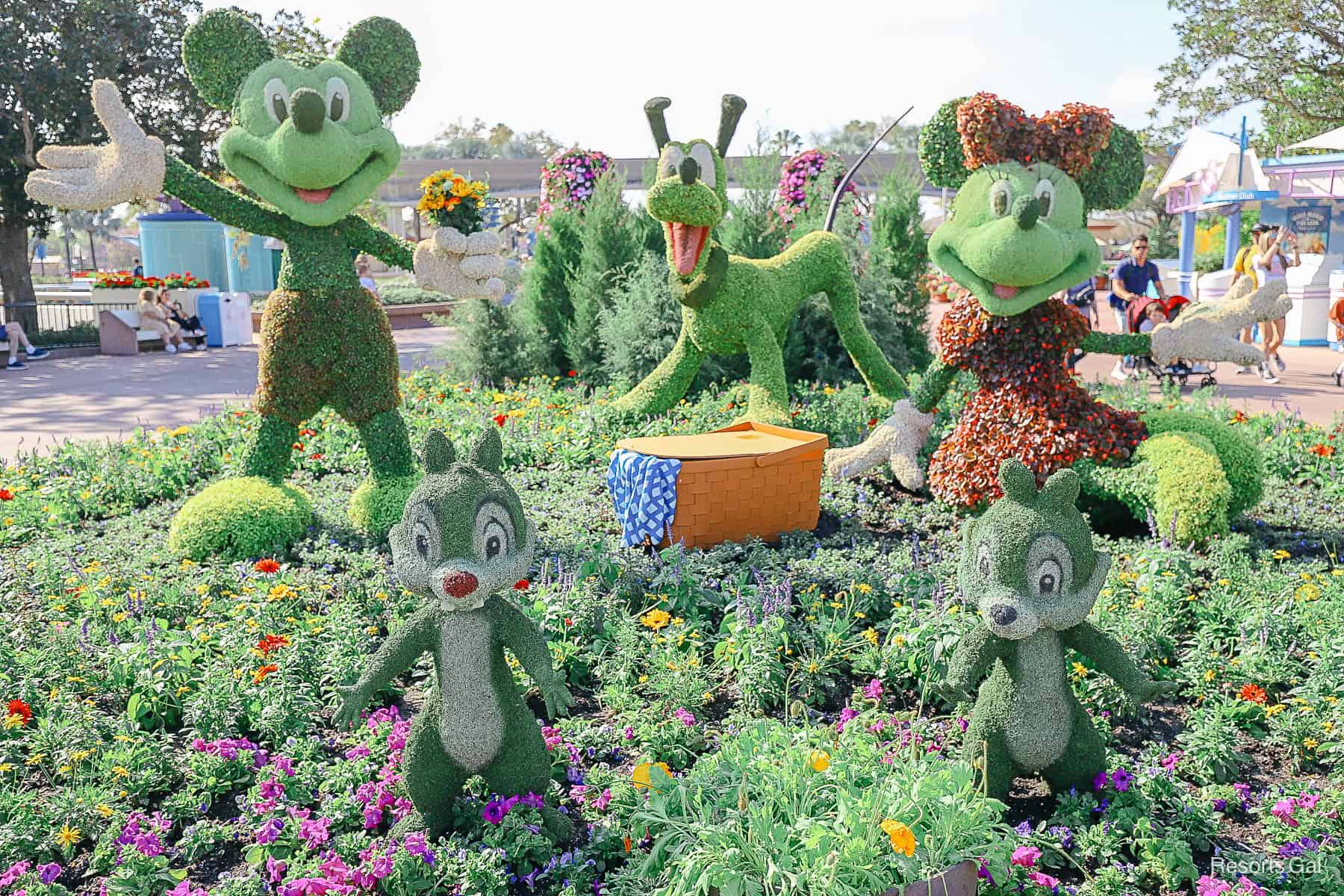 Mickey and Minnie with a picnic basket, Pluto in the background  and Chip and Dale toward the front. 