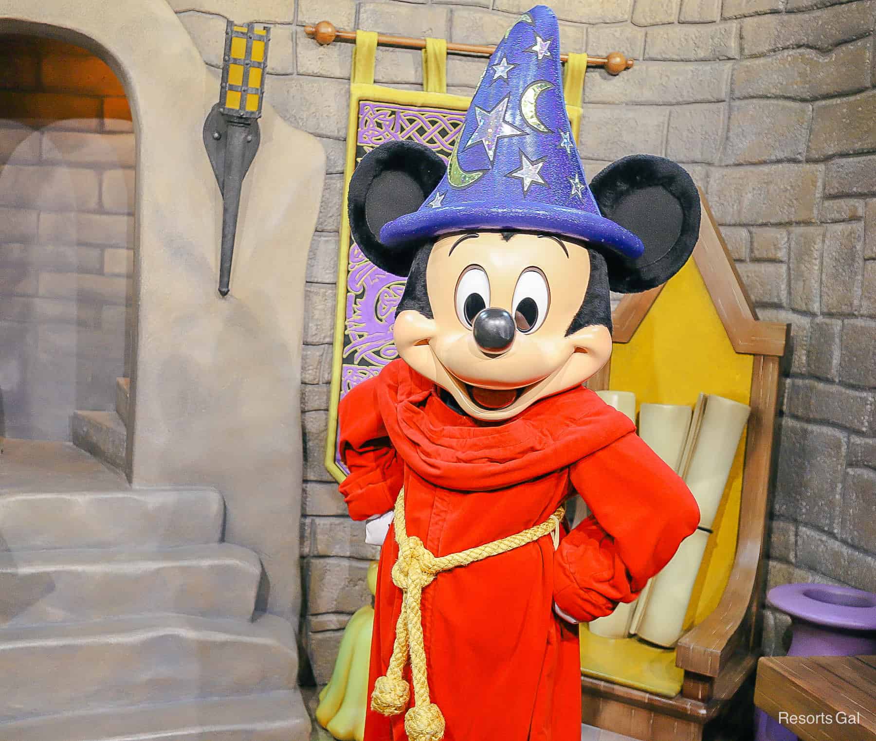 Mickey Mouse poses with red sorcerer robe and star with moon hat. 