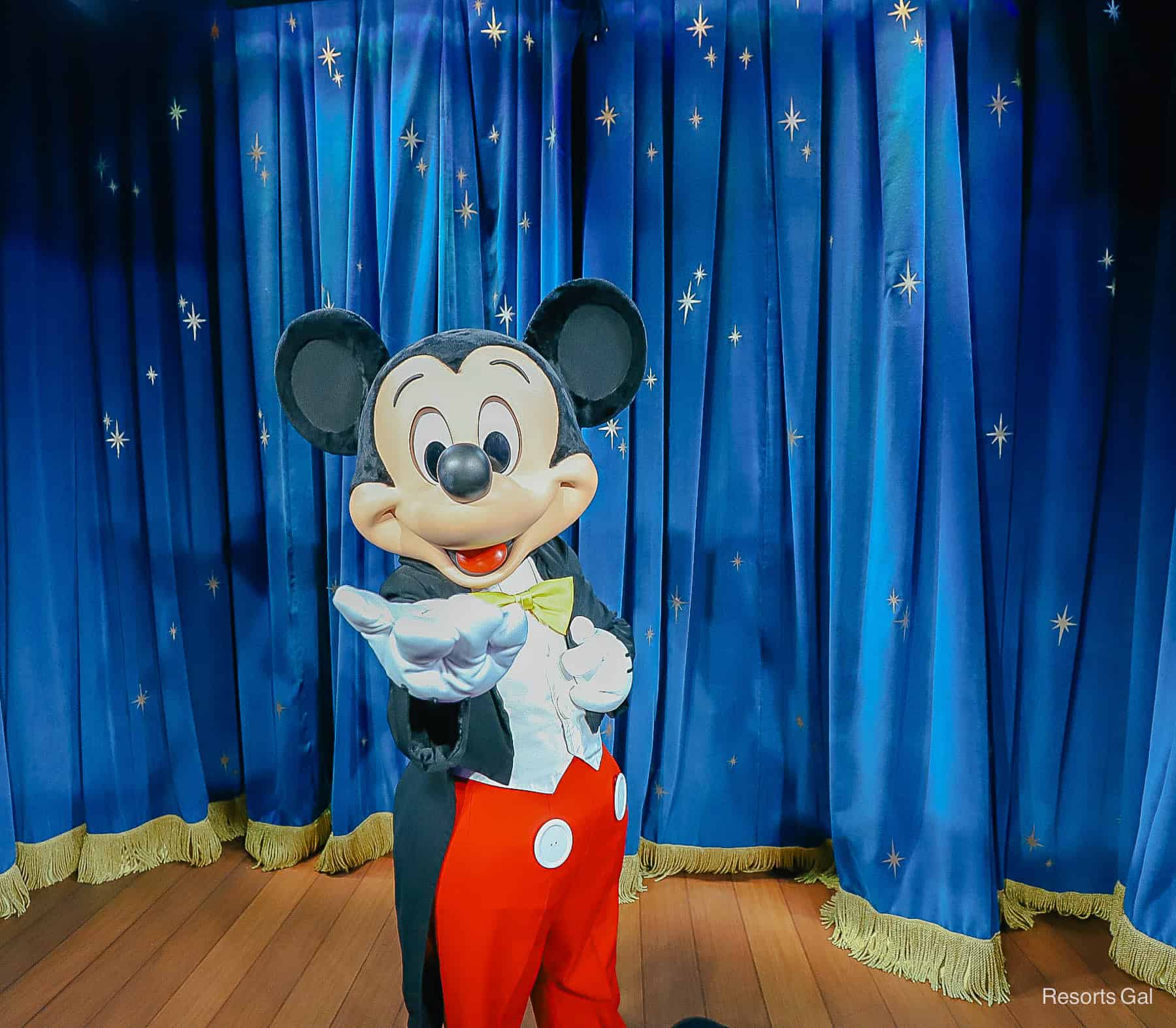 Mickey Mouse in his black jacket, yellow tie, and red pants. 