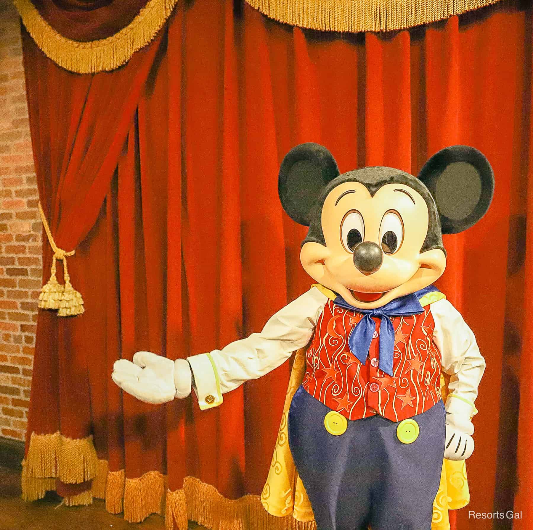 Mickey with one arm extended with red vest covered in stars. 