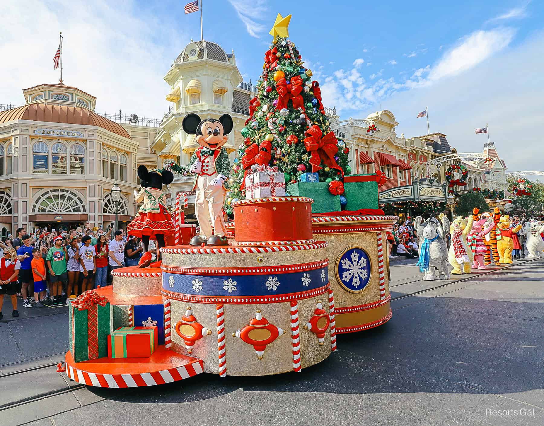 Christmas Parade float with a tree and presents and Mickey riding on the front in daytime. 