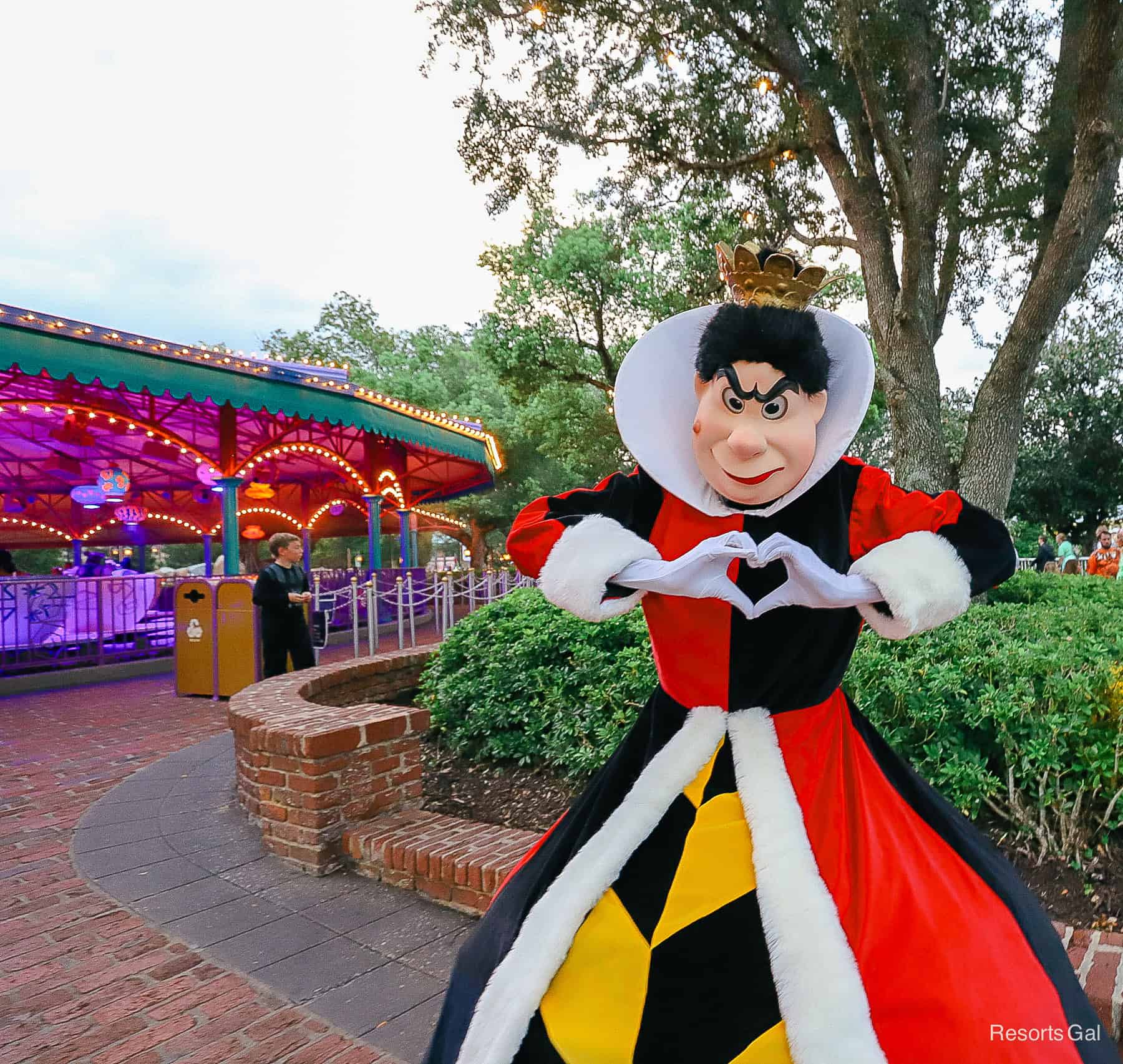 The Queen of Hearts poses for a photo making a heart shape with her hands at Mickey's Not So Scary Halloween Party. 