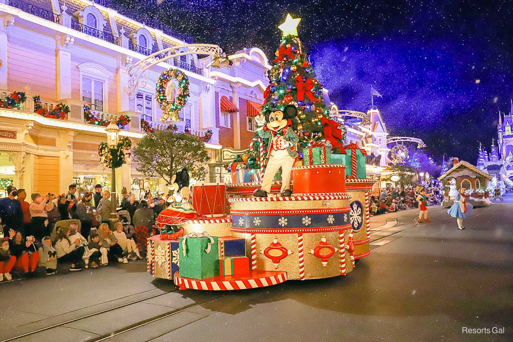 Mickey waves to guests as snow falls on Main Street 