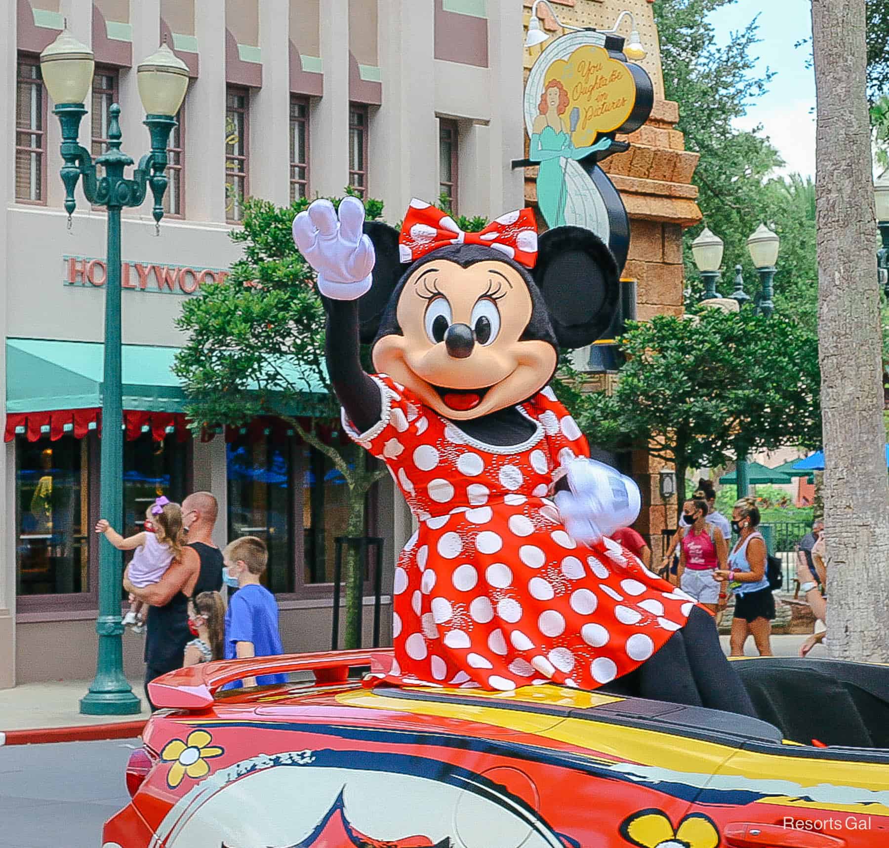 Minnie waves from a motorcade during social distancing. 