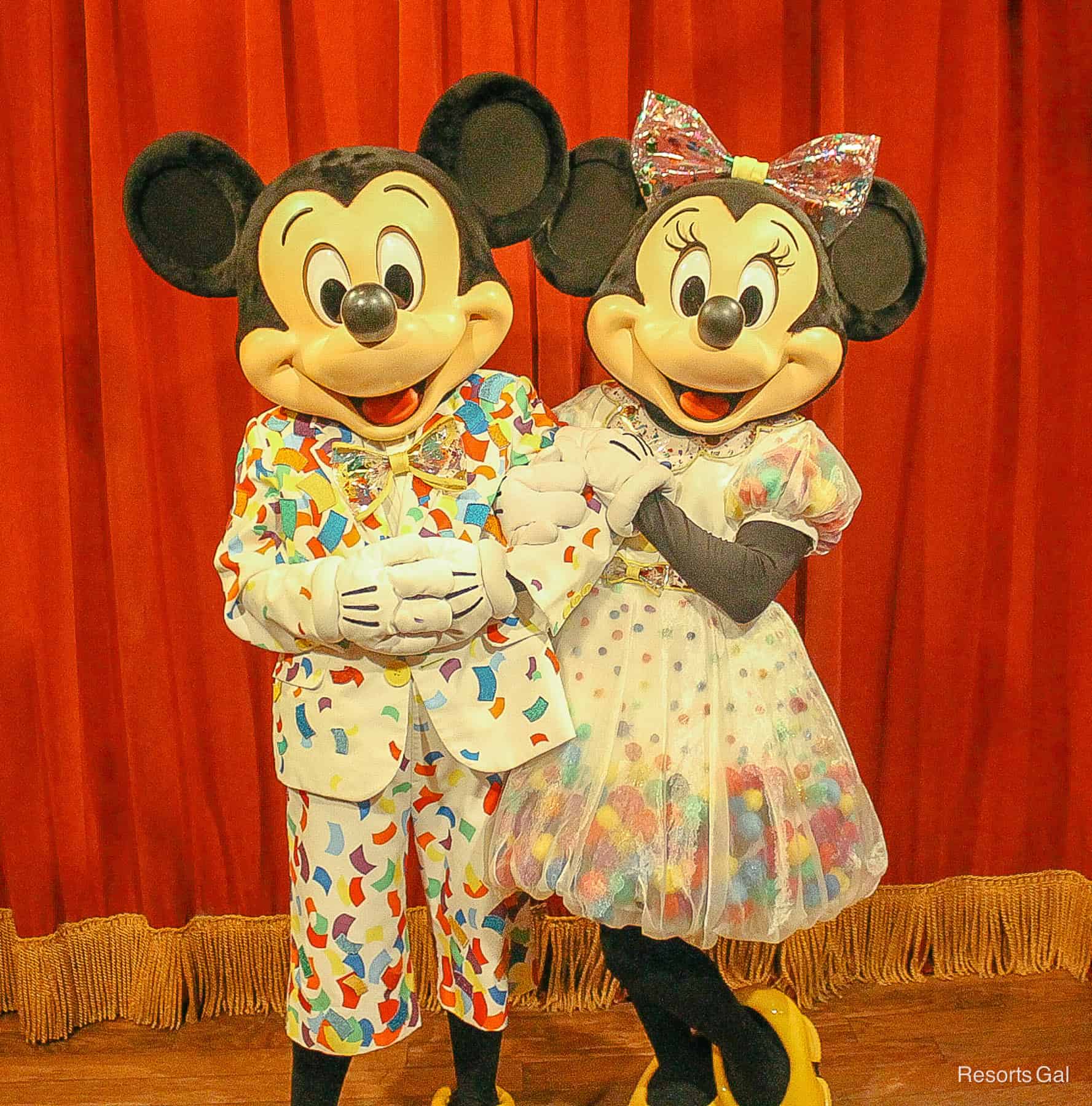 Mickey and Minnie at their 90th birthday celebration wearing confetti outfits. 