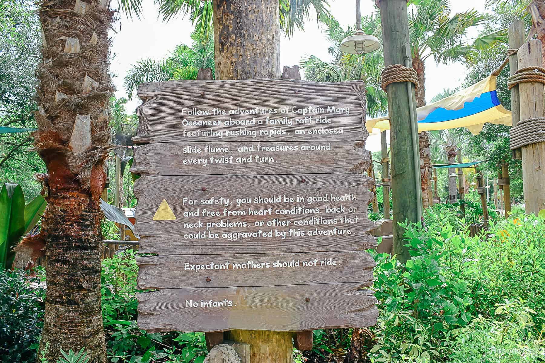 signage with warnings for Miss Adventure Falls near the ride's entrance 