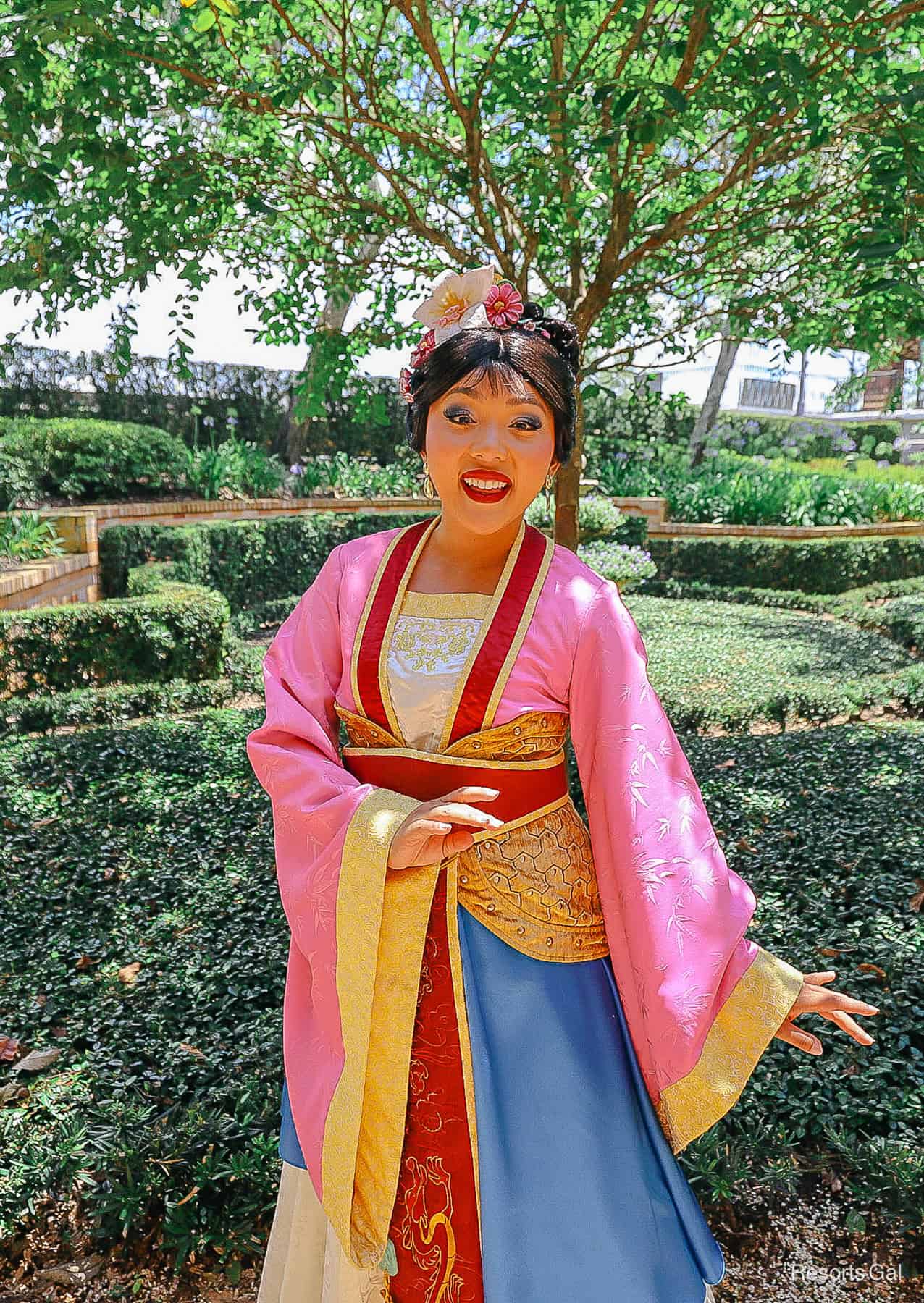 Mulan poses in her traditional dress for photos 