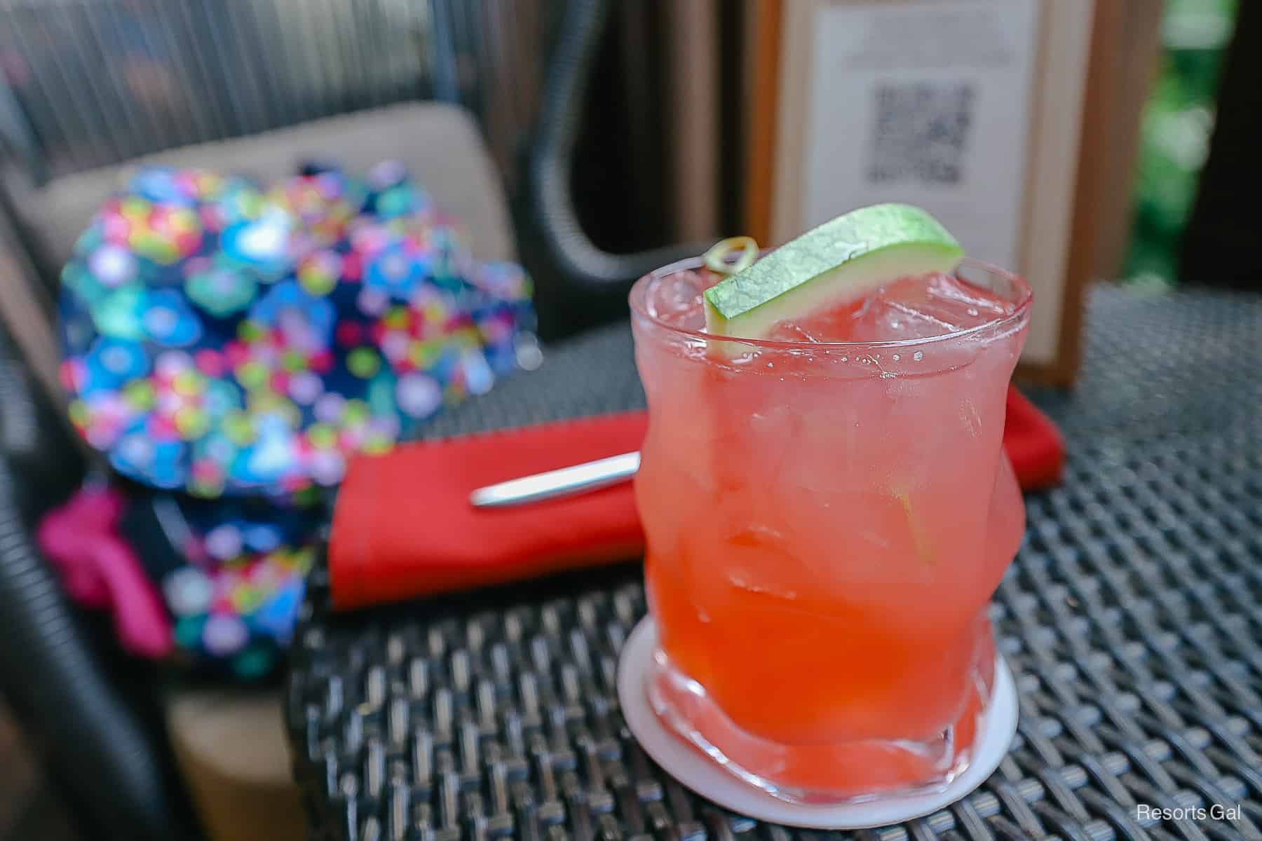 a pink drink with a wedge of a watermelon in it 