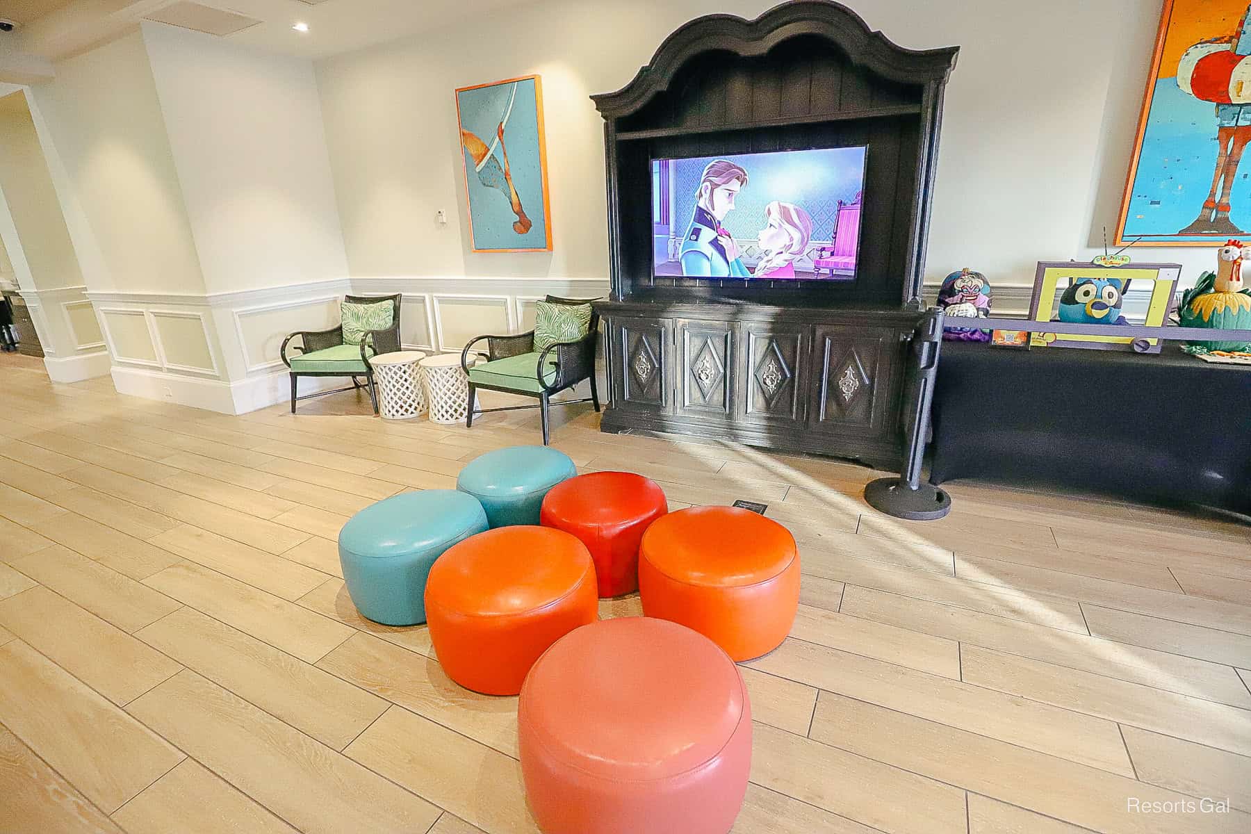 a children's seating area with stools and a television in the lobby 