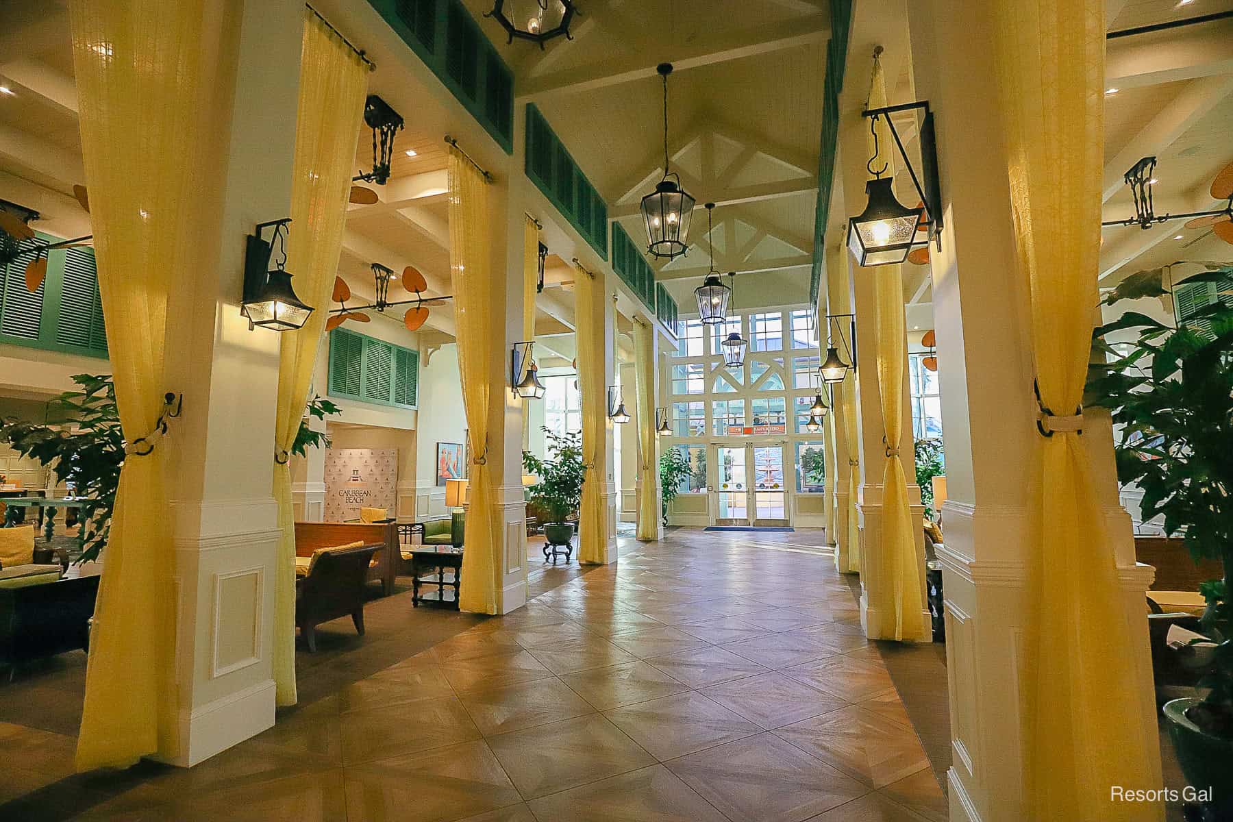 a long walkway through the center of the lobby with sheer curtains that hand on the columns from the floor to the ceiling 