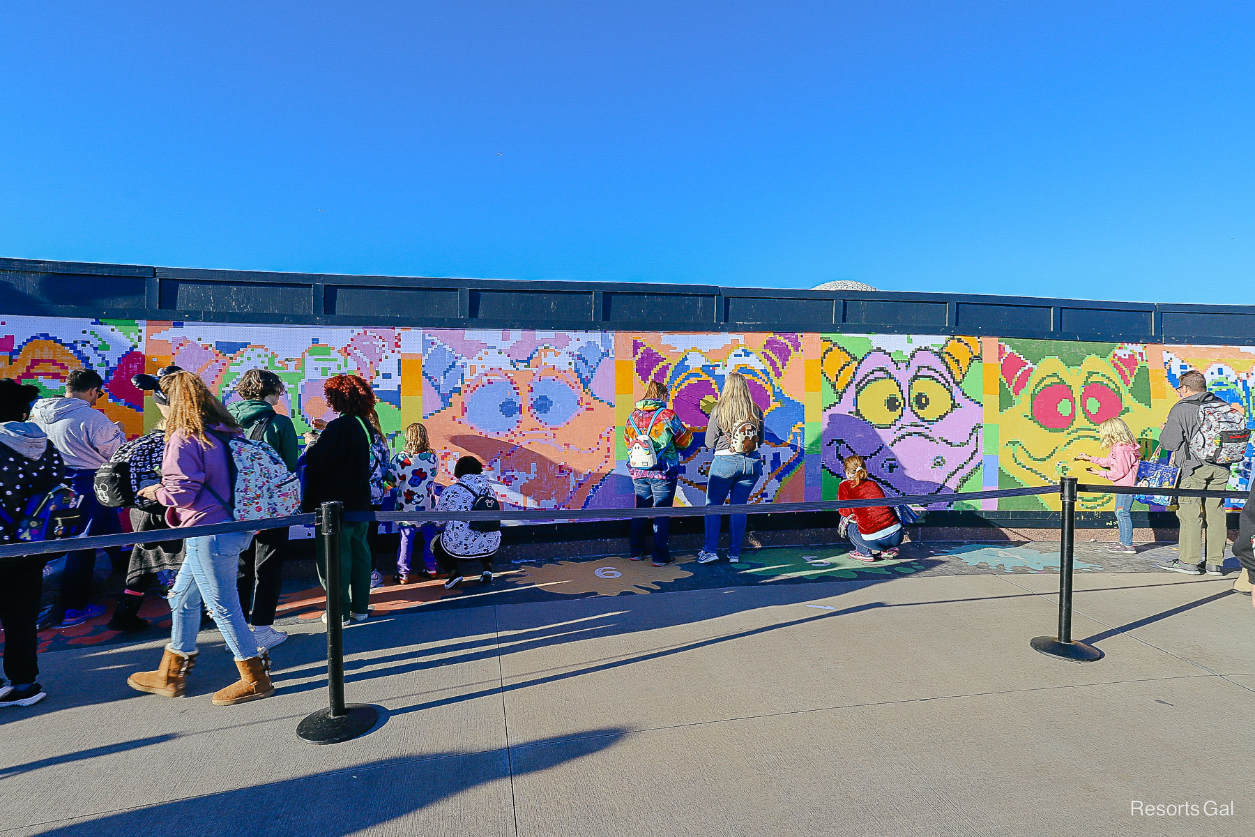 guests painting a mural with different representations of Figment, Epcot's mascot 