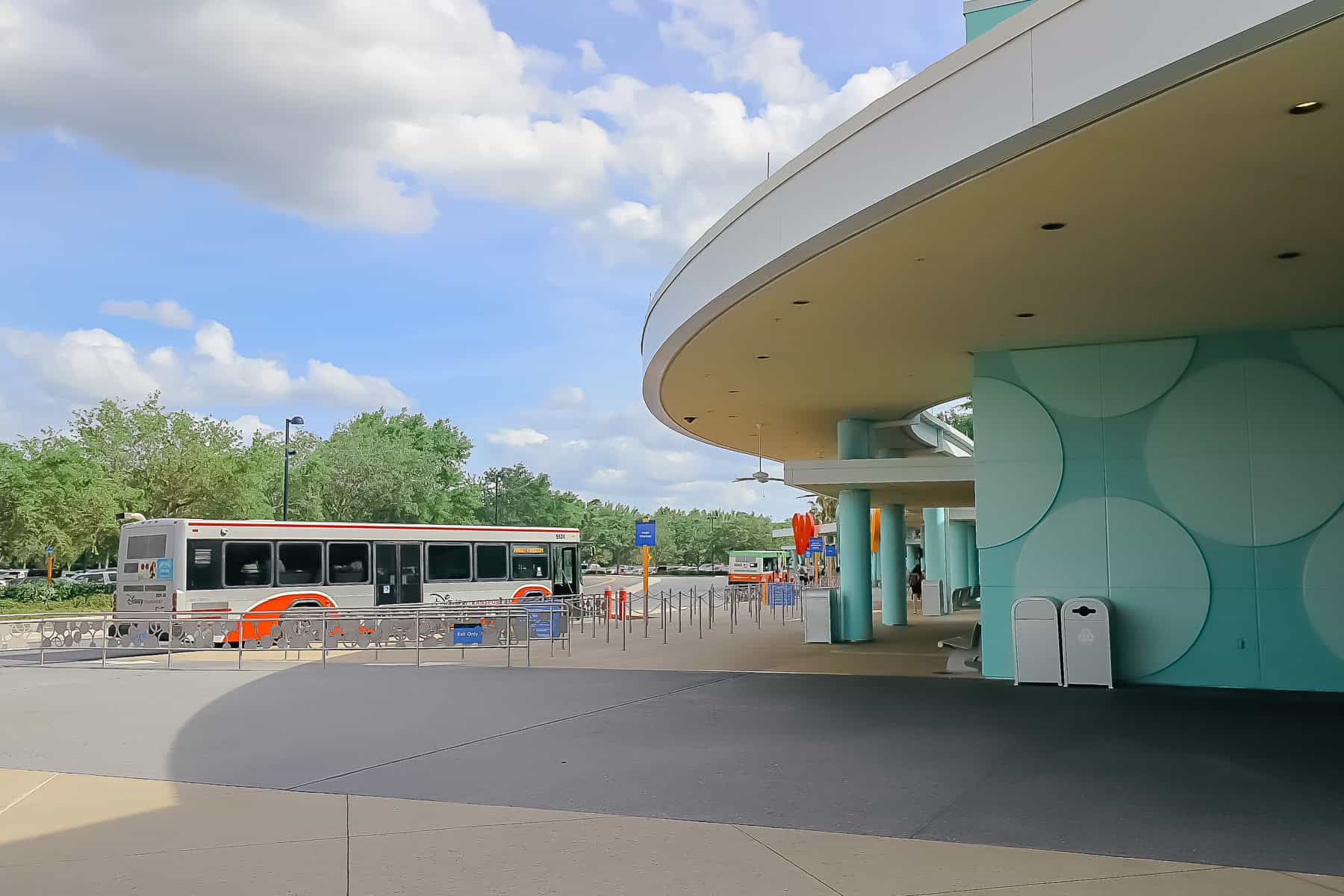 a bus arrives at the bus stop at Pop Century 