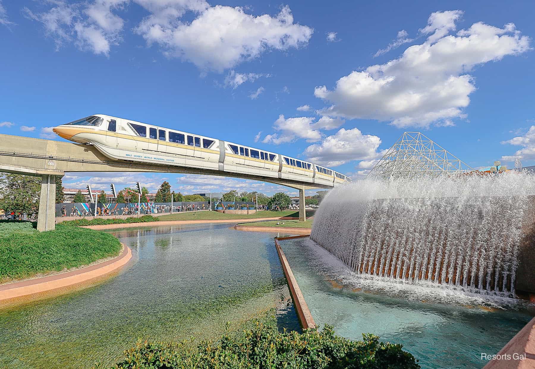 a monorail passing a fountain